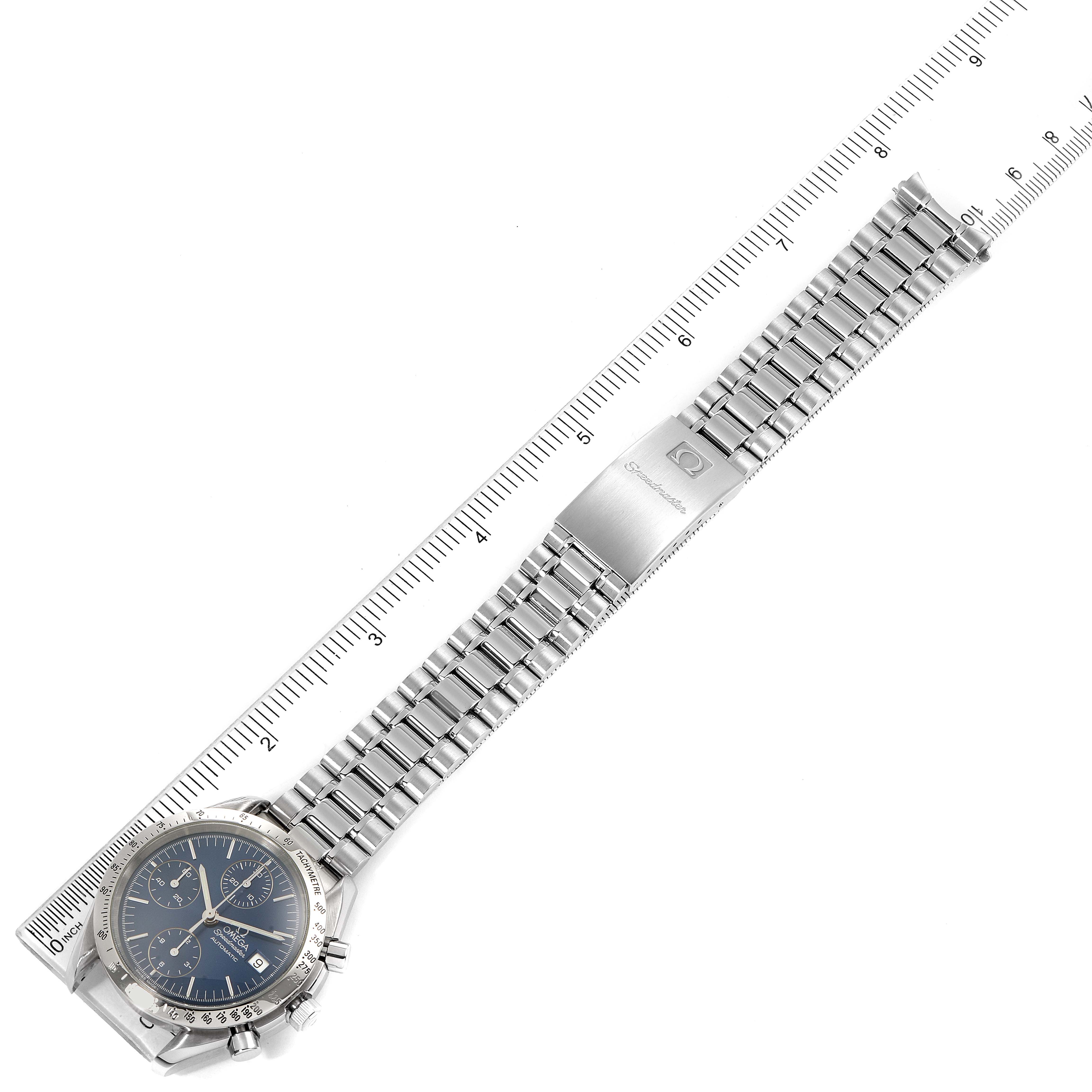 The Omega Speedmaster 3511.80.00 Men
s Stainless Steel Blue Dial 3511.80.00 Men
s Stainless Steel Blue Dial watch is shown from a top-down angle, emphasizing its dial and bracelet with a ruler alongside.