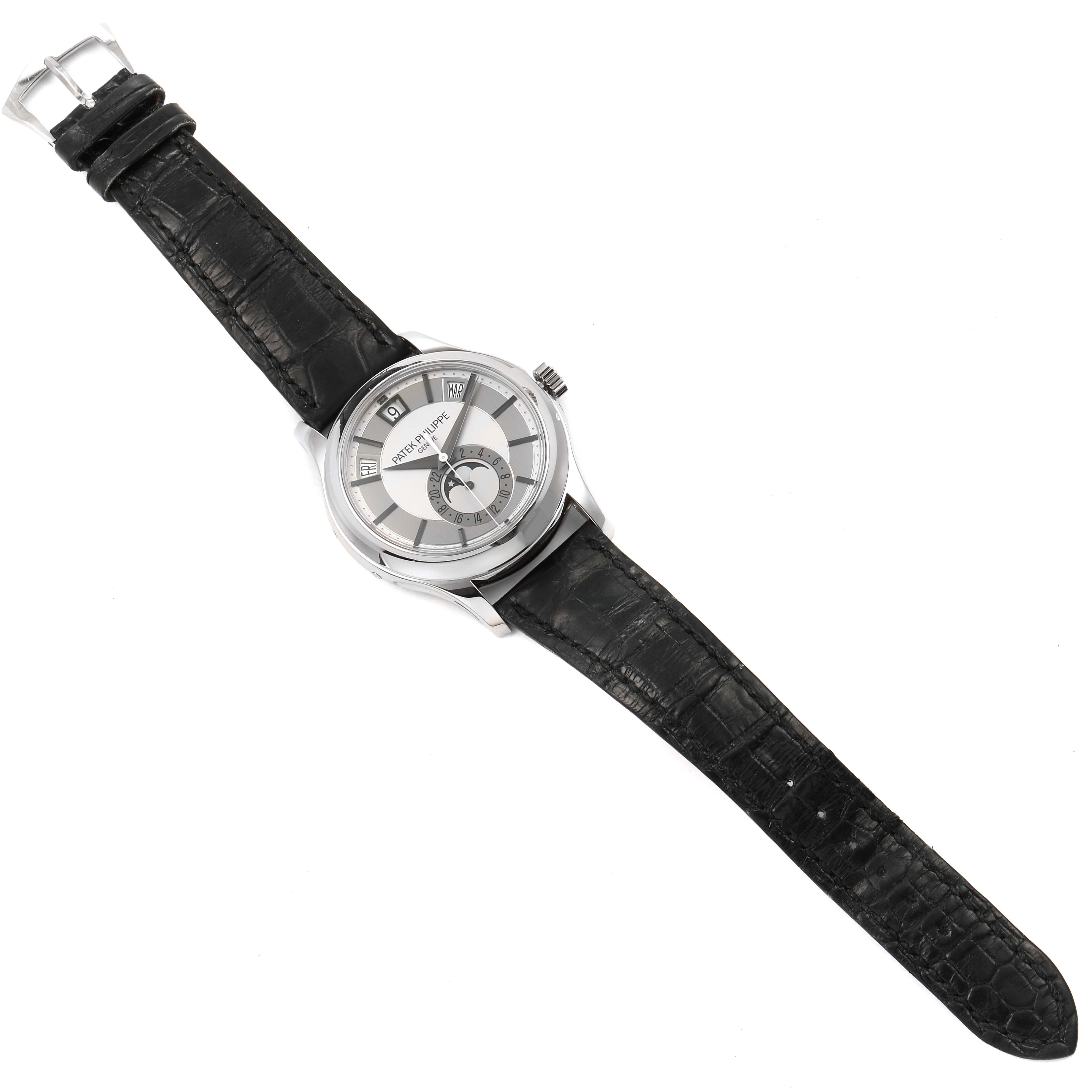 The image shows a top-down view of a Patek Philippe Complications 5205G  Men's White Gold Silver Dial 5205G  Men's White Gold Silver Dial watch with a black leather strap and a silver dial.