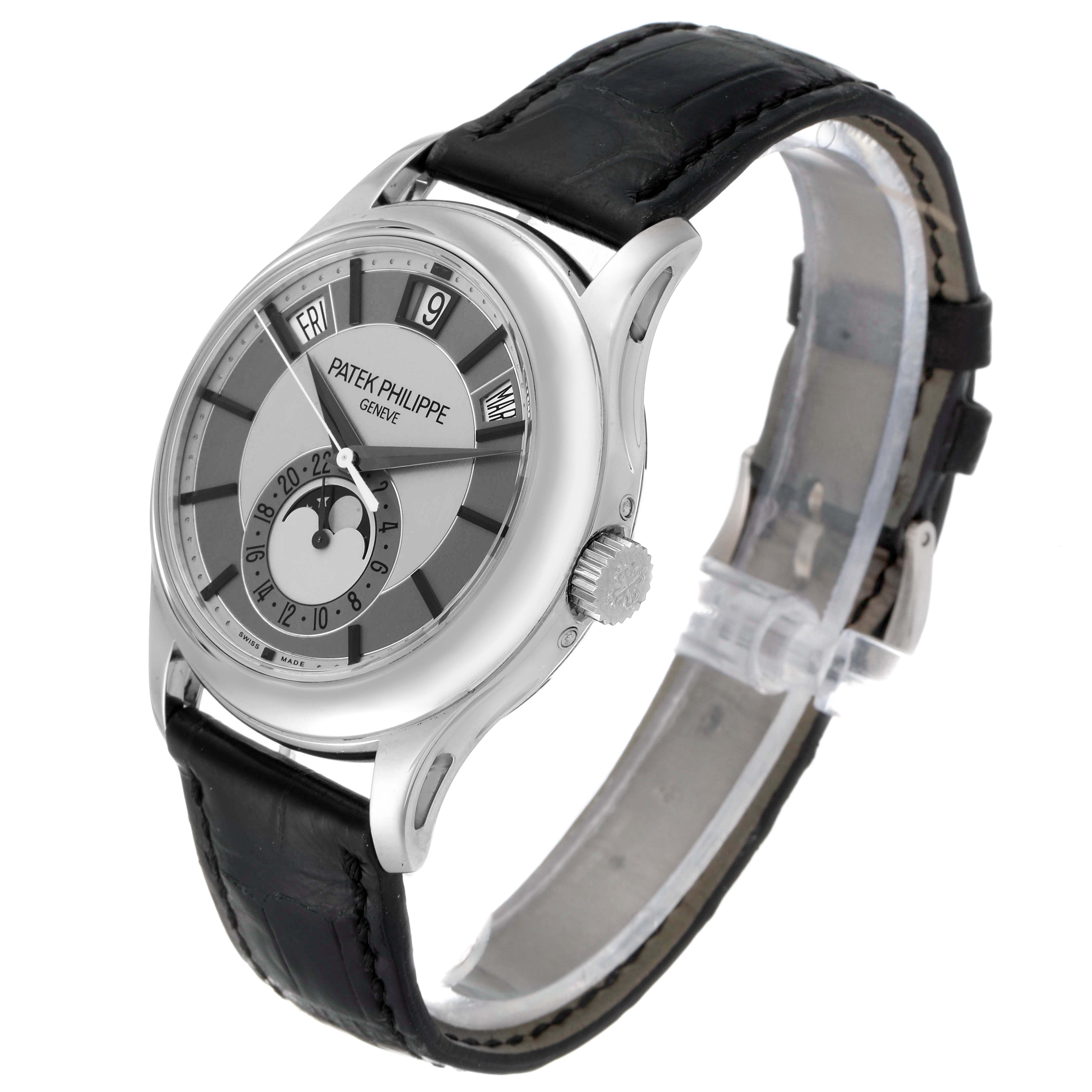 The image shows a side angle of a Patek Philippe Complications 5205G  Men's White Gold Silver Dial 5205G  Men's White Gold Silver Dial watch, highlighting its dial, crown, and black leather strap.