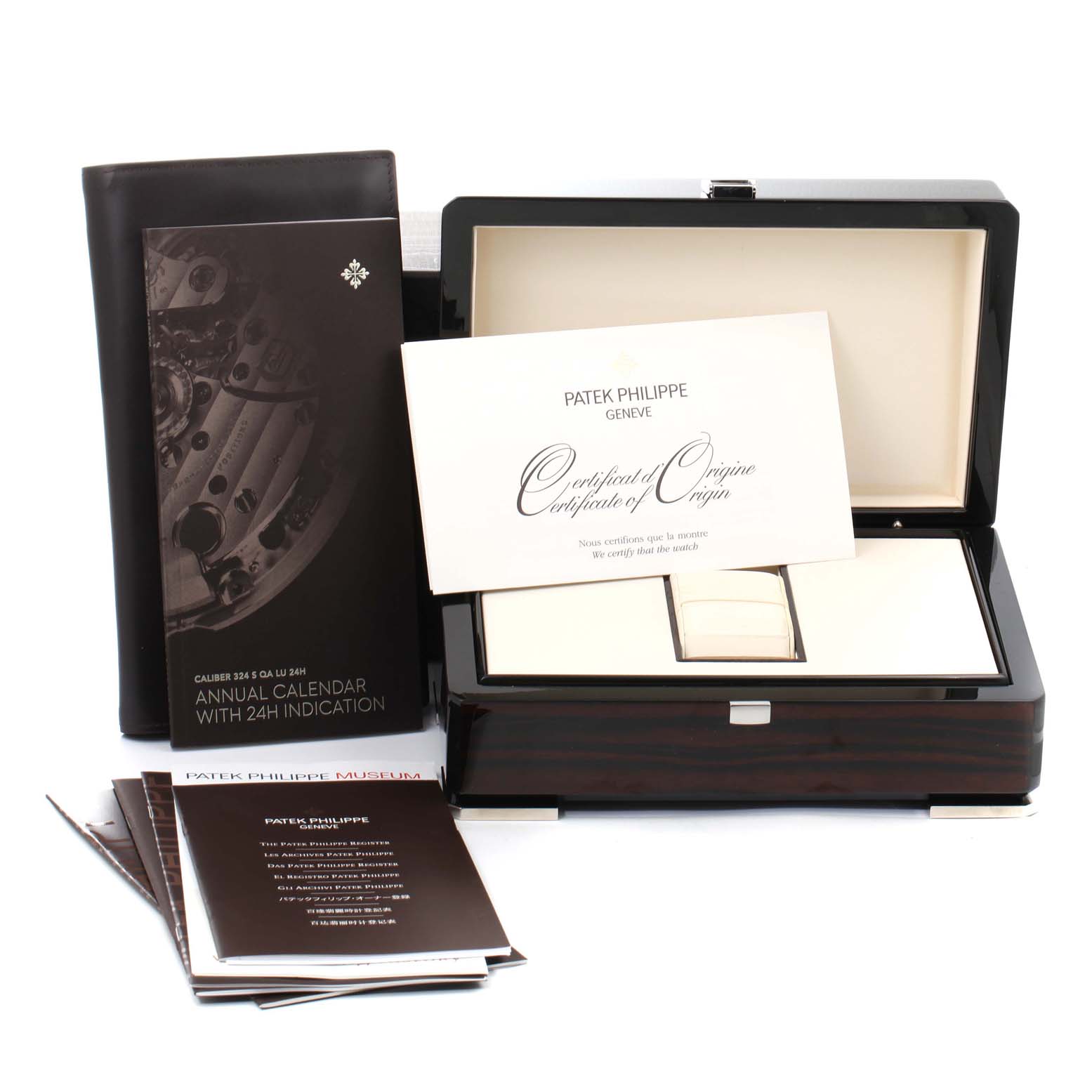 The image shows the box, certificates, and manuals of the Patek Philippe Complications 5205G  Men's White Gold Silver Dial 5205G  Men's White Gold Silver Dial model Annual Calendar with 24-hour indication.