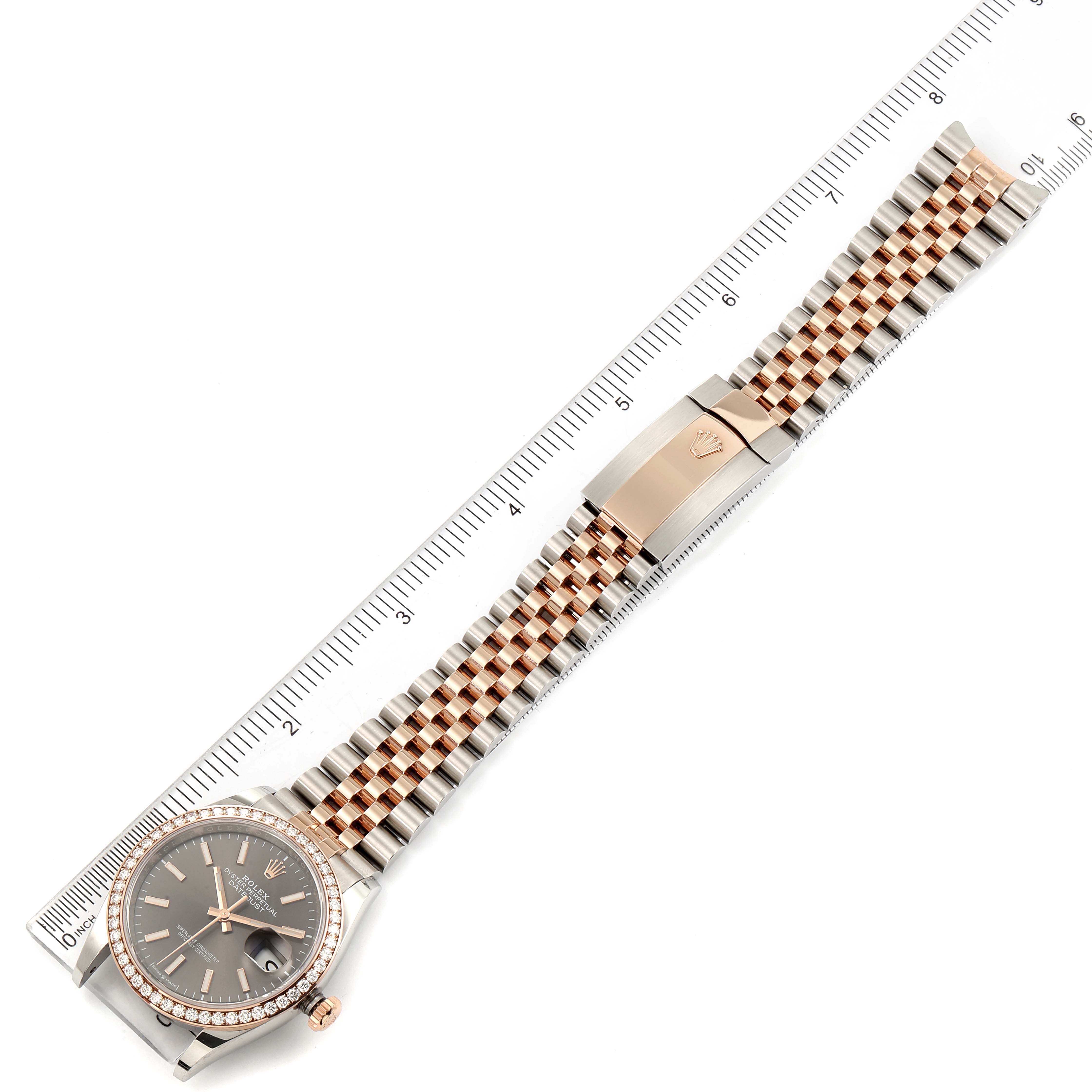 This image shows the entire Rolex Datejust 126281 Men
s Steel and Gold (two tone) Grey Dial 126281 Men
s Steel and Gold (two tone) Grey Dial watch from a top-down angle, including the dial, bezel, bracelet, and clasp alongside a ruler.