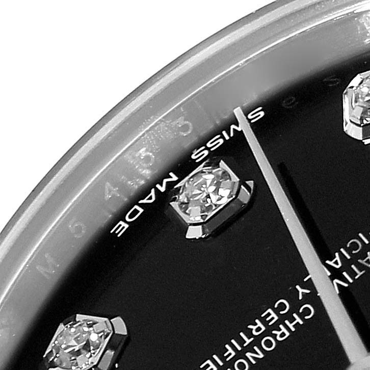 This close-up of the Rolex Mid-Size 178274 Women's Stainless Steel Black Dial 178274 Women's Stainless Steel Black Dial model watch shows part of the dial with diamond hour markers, a "SWISS MADE" label, and the second hand.