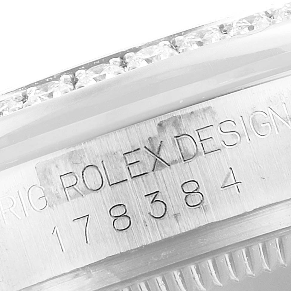 The image shows a close-up angle of the bezel and case side of a Mid-Size Rolex watch, highlighting the serial number and "ROLEX DESIGN" engraving.