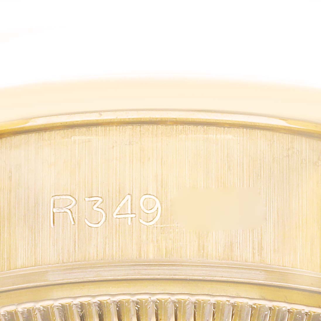 This image shows a close-up of the engraved serial number on the case back of a Rolex President 69138 Women's Yellow Gold Black Dial 69138 Women's Yellow Gold Black Dial model watch.