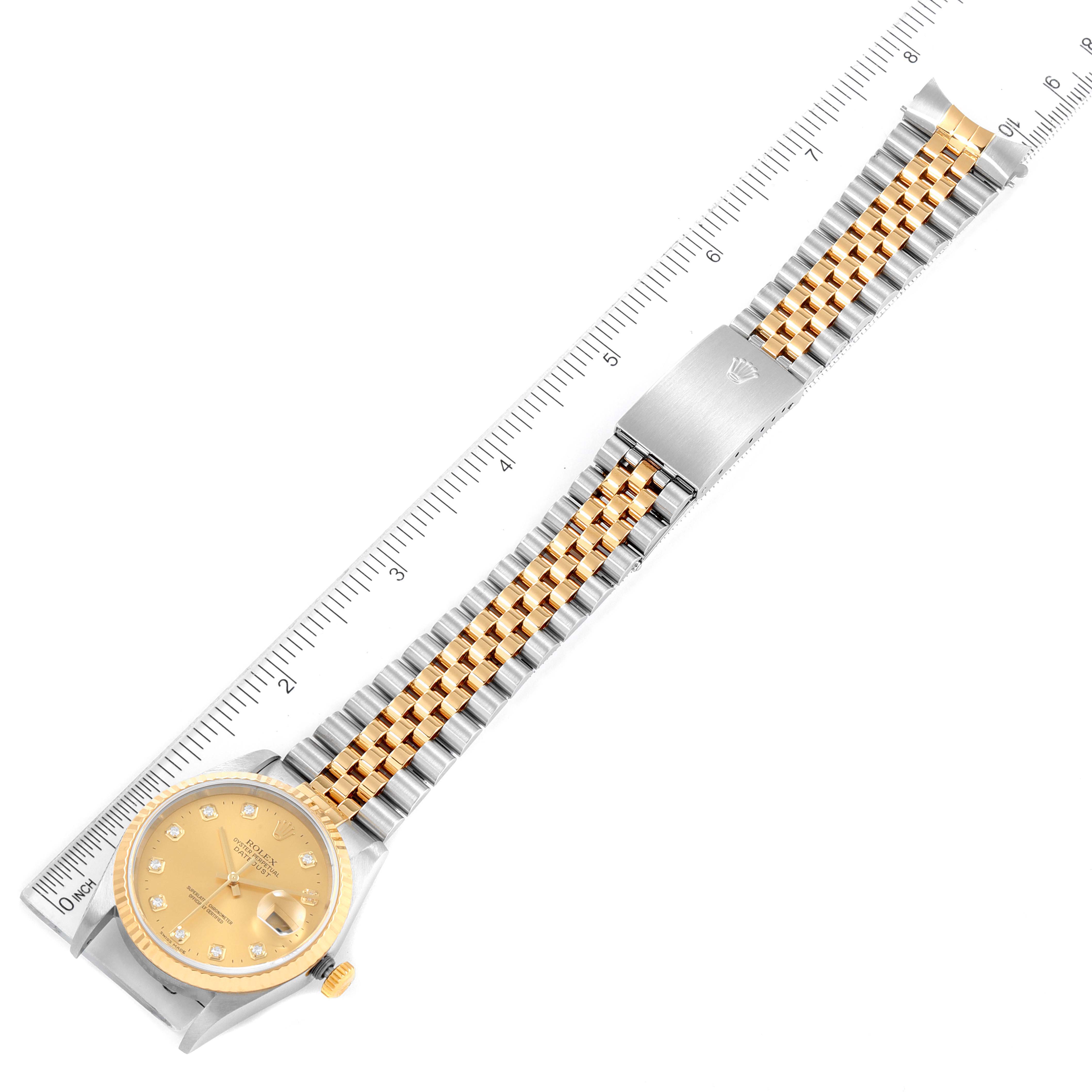 The image shows a full Datejust model Rolex watch laid flat with its bracelet aligned alongside a ruler.