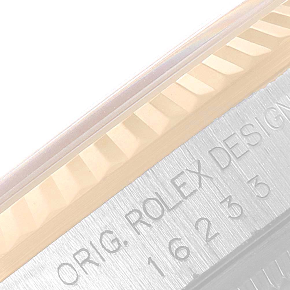 The image shows a close-up view of the fluted bezel and part of the case inscription of a Rolex Datejust 16233 Men's Steel and Gold (two tone) Champagne Dial 16233 Men's Steel and Gold (two tone) Champagne Dial model watch.