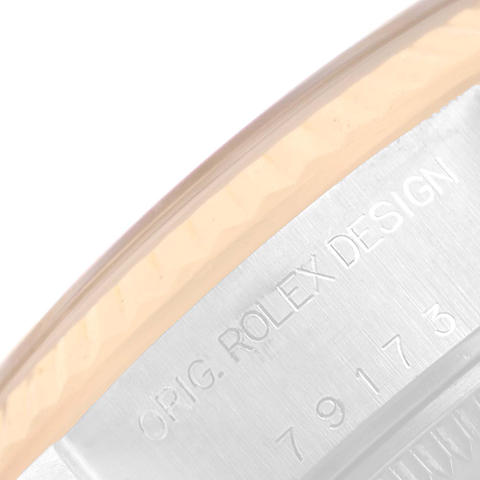 The image shows a close-up of the side of a Rolex Datejust 79173 Women
s Steel and Gold (two tone) Champagne Dial 79173 Women
s Steel and Gold (two tone) Champagne Dial watch, displaying the engraved "ORIG. ROLEX DESIGN" and serial number.