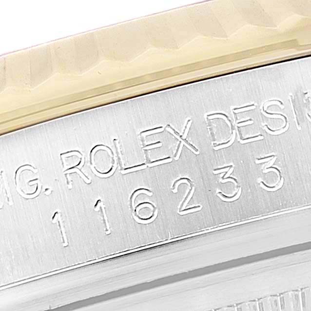 The image shows a close-up of the engraved casing side of a Rolex Datejust 116233 Men's Steel and Gold (two tone) Champagne Dial 116233 Men's Steel and Gold (two tone) Champagne Dial, highlighting the serial number and design engraving.