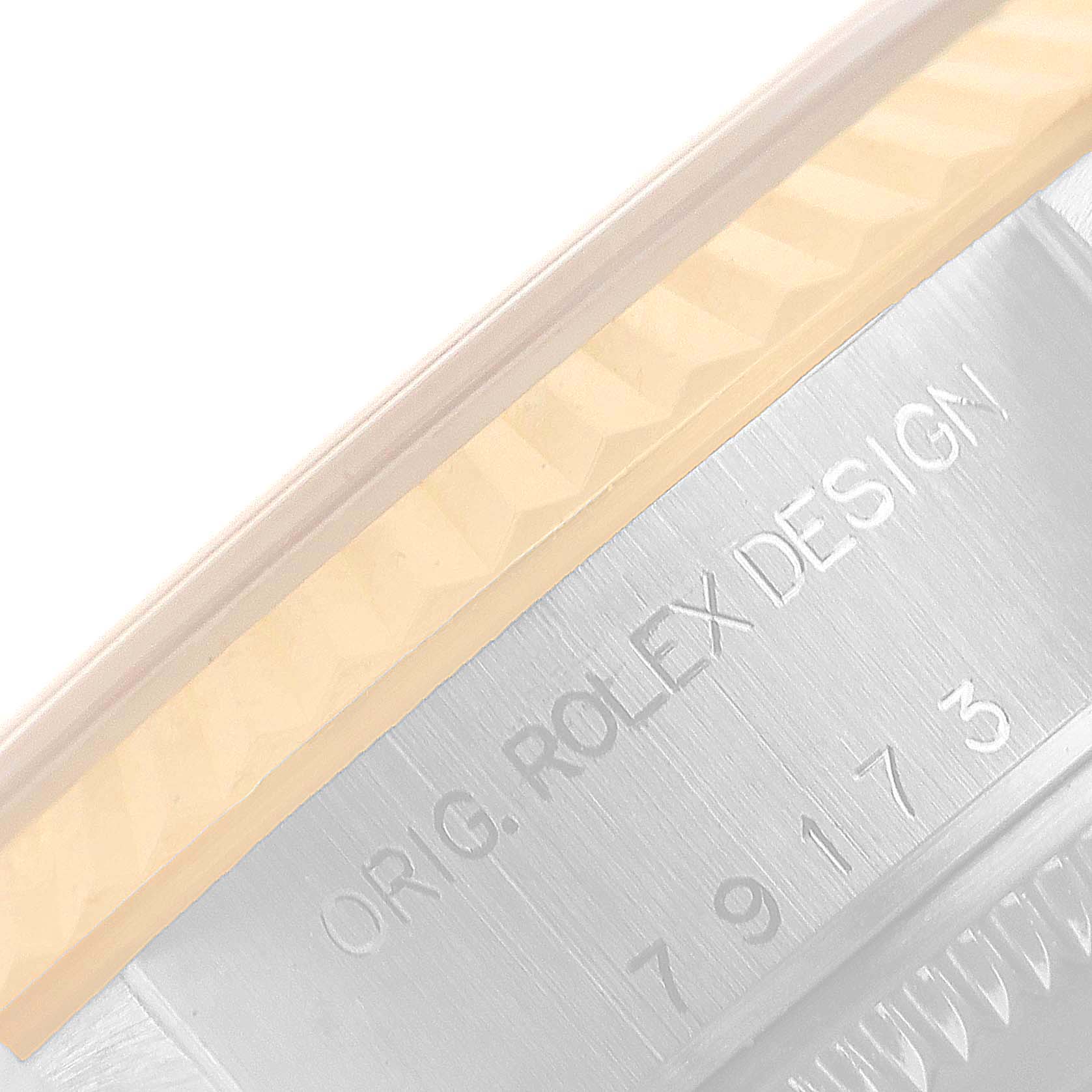 This image shows a close-up of the side of a Rolex Datejust 79173 Women
s Steel and Gold (two tone) White Dial 79173 Women
s Steel and Gold (two tone) White Dial model, highlighting the engraved "ORIG. ROLEX DESIGN" inscription.