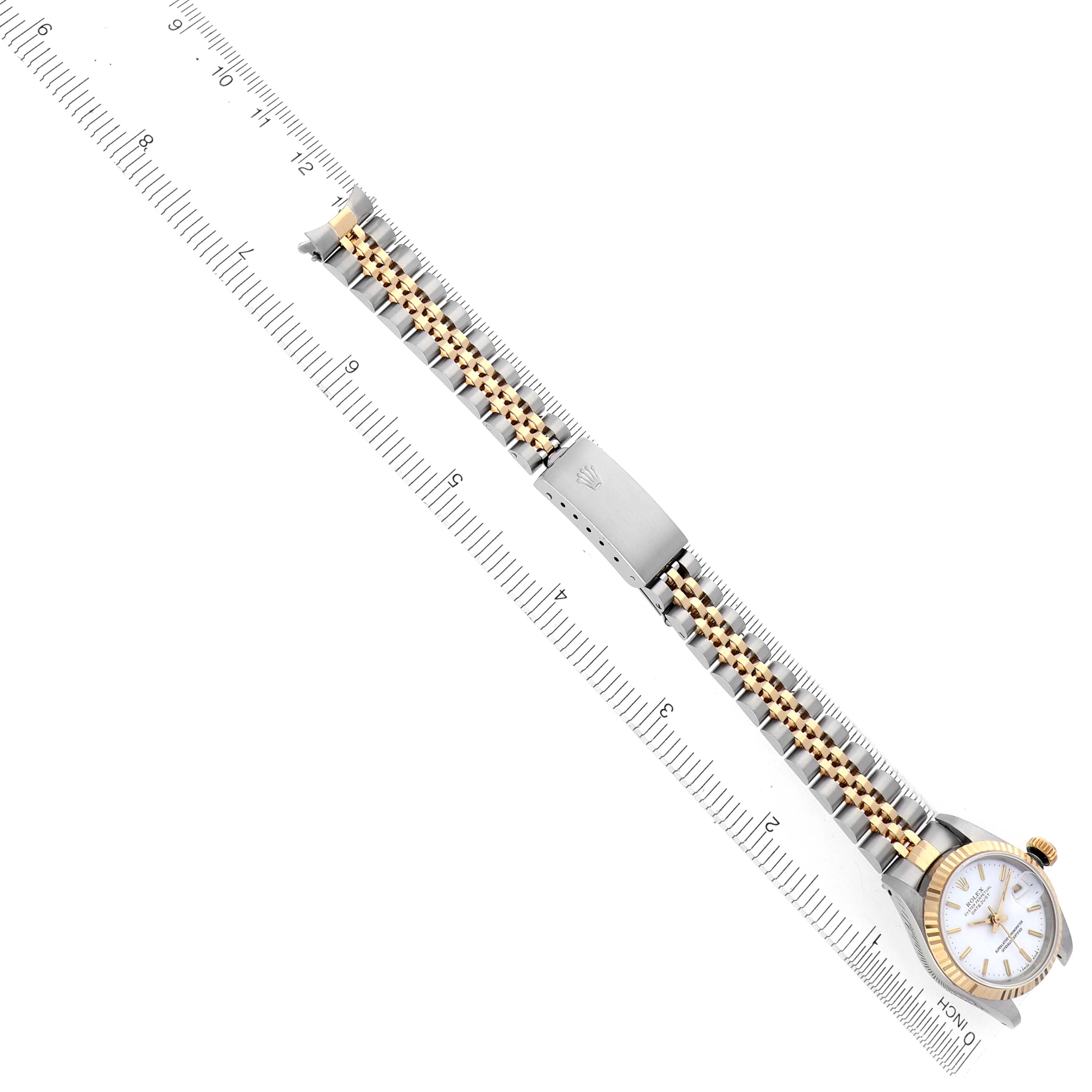 The Rolex Datejust 69173 Women's Steel and Gold (two tone) White Dial 69173 Women's Steel and Gold (two tone) White Dial watch is shown at an angle, highlighting its face, bracelet, and clasp beside a ruler for scale.