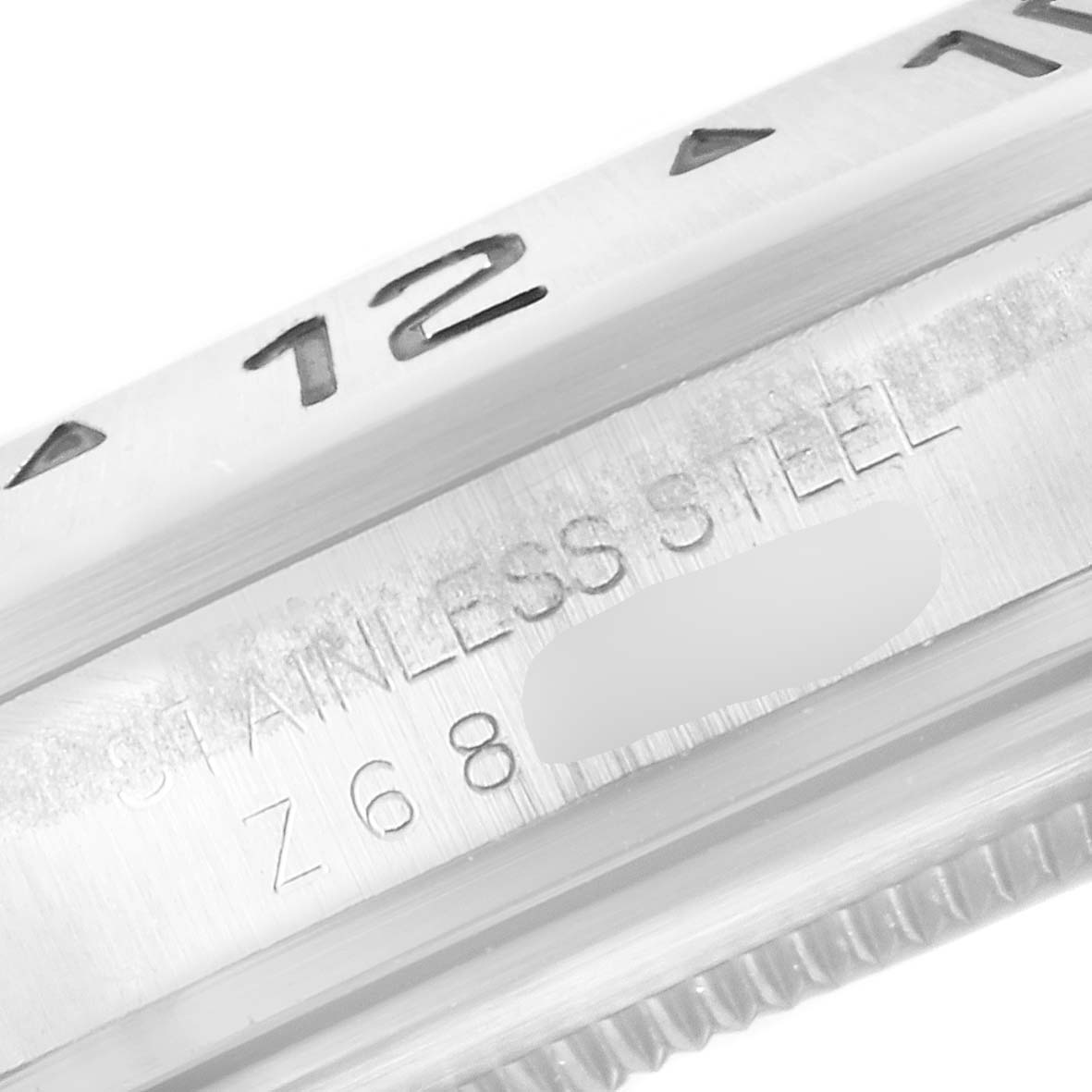 This close-up image shows part of the stainless steel bezel and case of a Rolex Explorer 16570 Men's Stainless Steel White Dial 16570 Men's Stainless Steel White Dial watch.