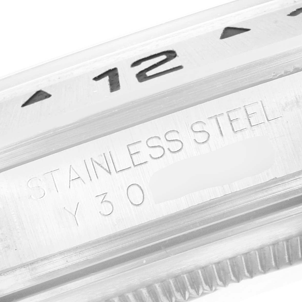 This image shows a close-up of the bezel and side engraving of a Rolex Explorer 16570 Men's Stainless Steel White Dial 16570 Men's Stainless Steel White Dial watch, highlighting "Stainless Steel" and part of the serial number.