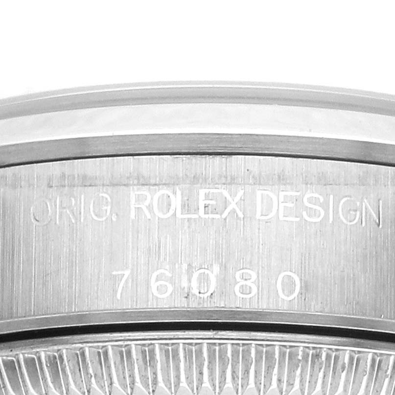 The image shows a close-up of the side of the Rolex Oyster Perpetual 76080 Women's Stainless Steel Black Dial 76080 Women's Stainless Steel Black Dial watch, highlighting the engraved model number and design branding.