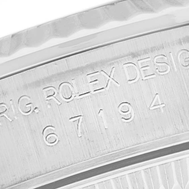 The image shows a close-up of the serial number and engravings on the case side of a Rolex Oyster Perpetual 67194 Women's Stainless Steel Black Dial 67194 Women's Stainless Steel Black Dial watch.