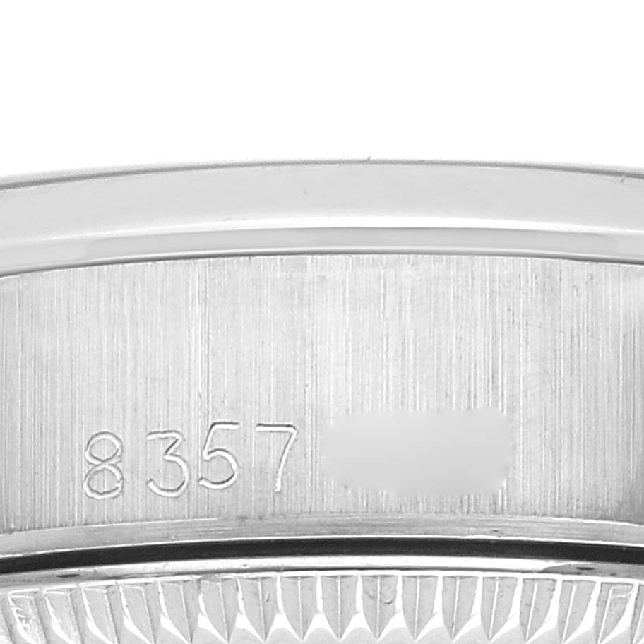The image shows a close-up angle of the serial number engraving and fluted edge on a Rolex Oyster Perpetual 67180 Women's Stainless Steel Silver Dial 67180 Women's Stainless Steel Silver Dial model.