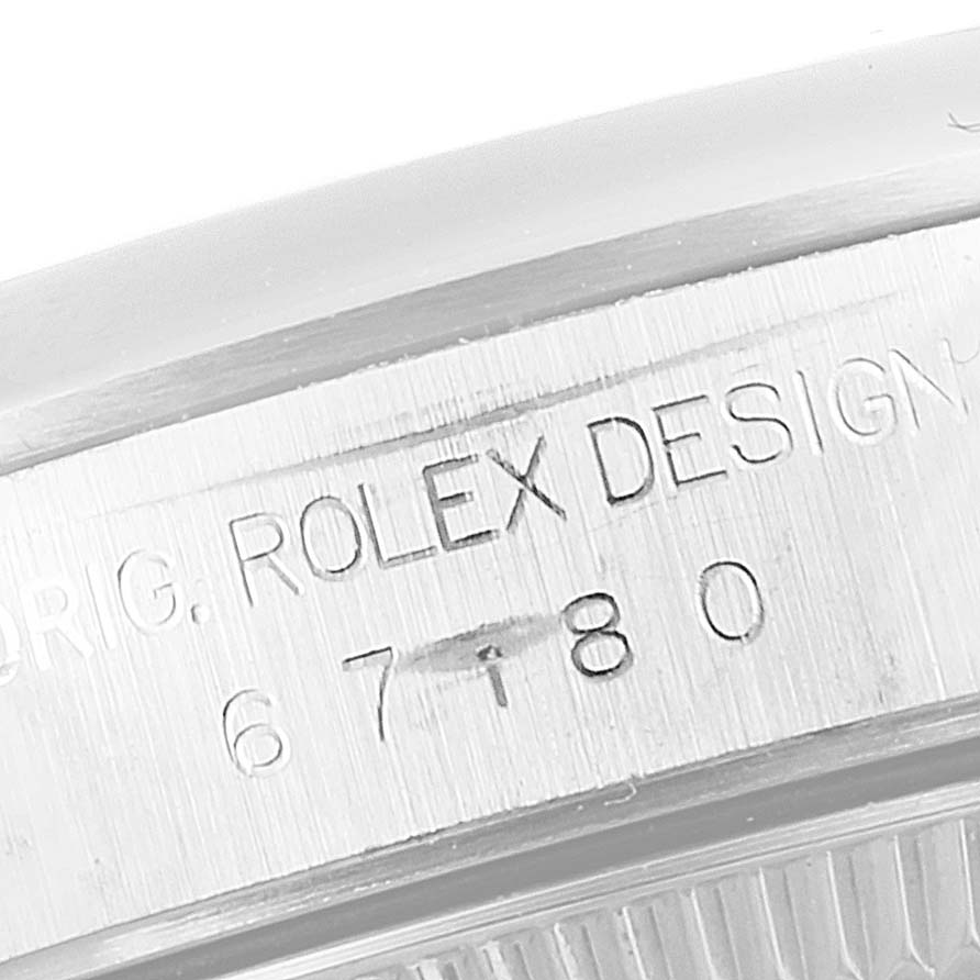 The image shows a close-up of the serial engraving on the side of a Rolex Oyster Perpetual 67180 Women's Stainless Steel Pink Dial 67180 Women's Stainless Steel Pink Dial watch case.
