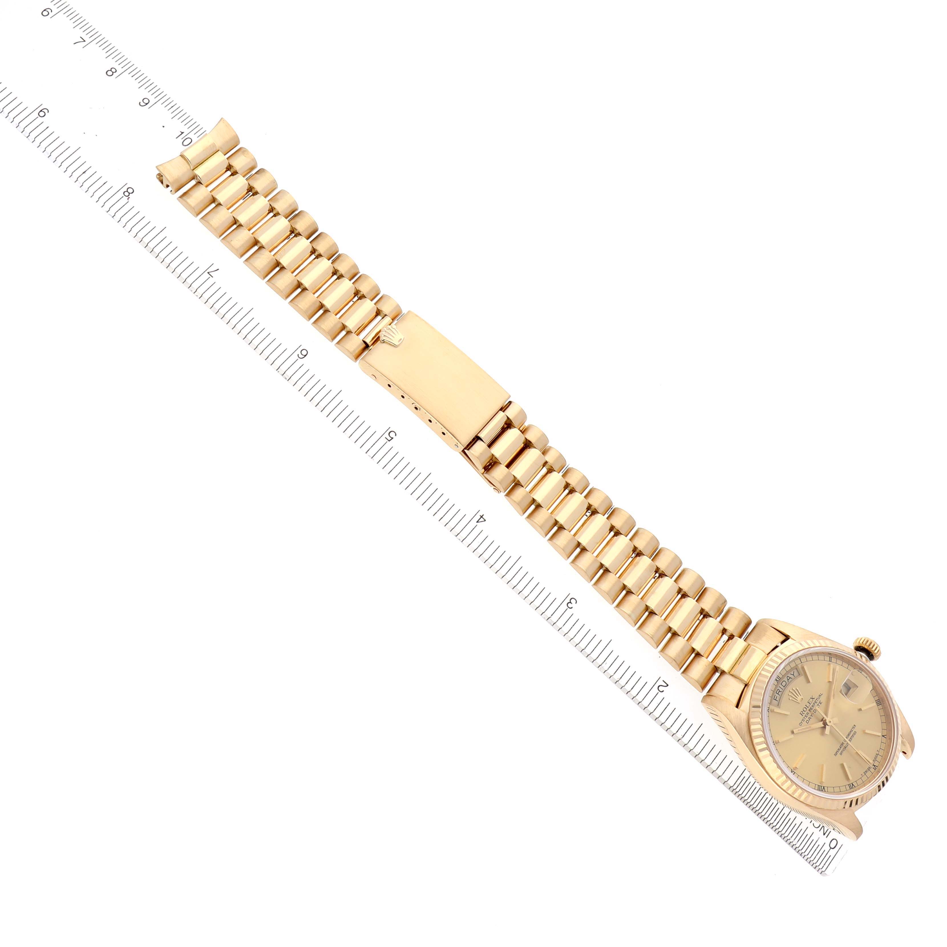 The Rolex President 18038 Men's Yellow Gold Champagne Dial 18038 Men's Yellow Gold Champagne Dial watch is laid flat, showing the full bracelet, clasp, and face against a ruler for scale.