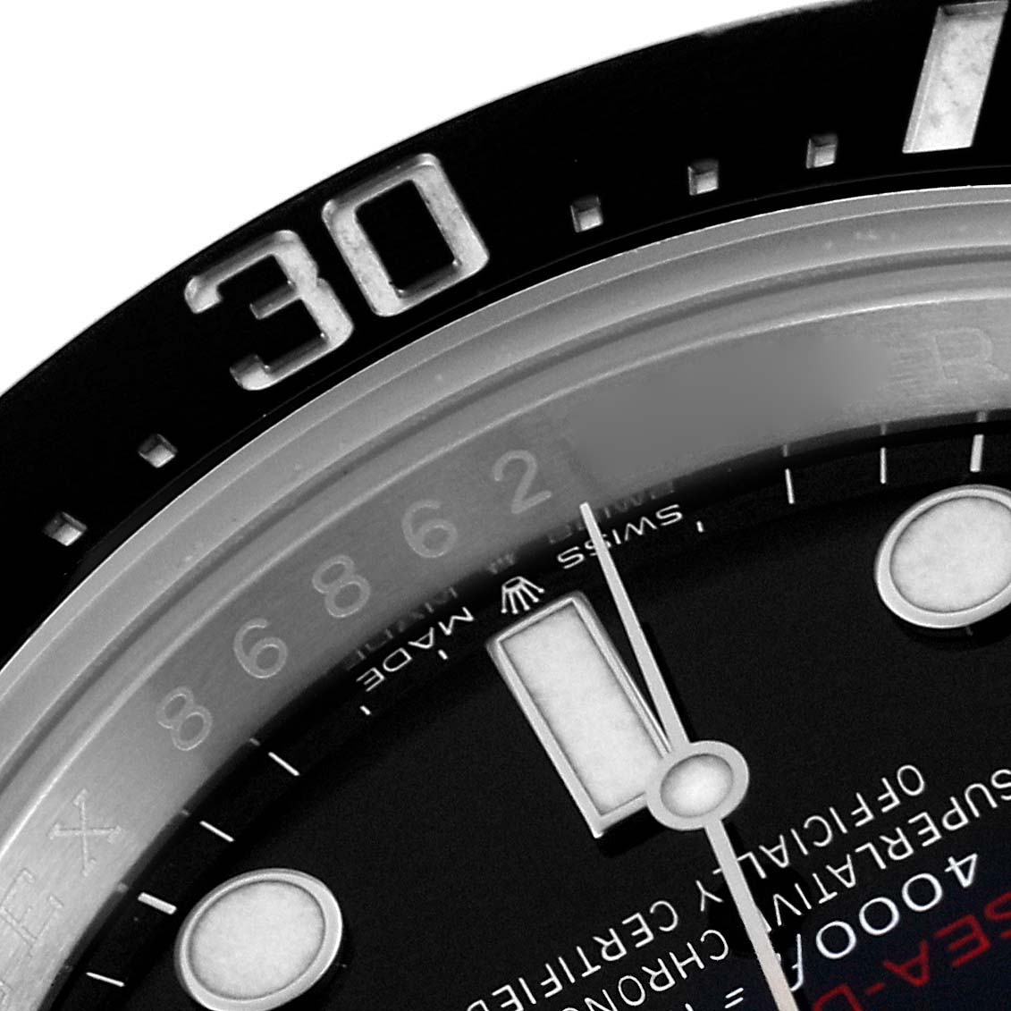The image shows a close-up of the Rolex Sea-Dweller 126600 Men's Stainless Steel Black Dial 126600 Men's Stainless Steel Black Dial's dial and bezel, focusing on the 30-minute mark and watch hands.