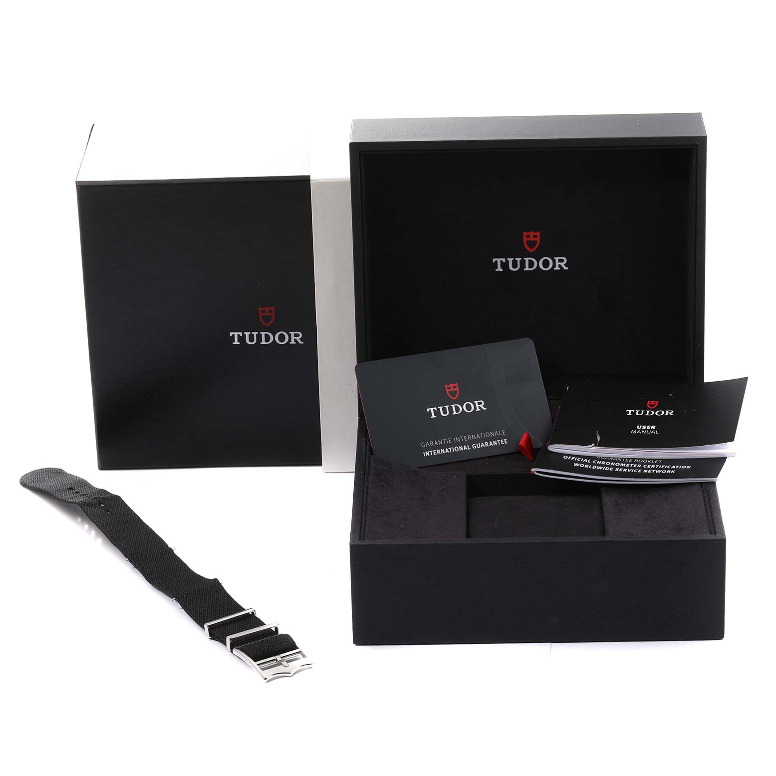 The image shows the Tudor Heritage Black Bay 79230G Men
s Stainless Steel Black Dial 79230G Men
s Stainless Steel Black Dial watch packaging with accessories, including a watch strap and documentation.
