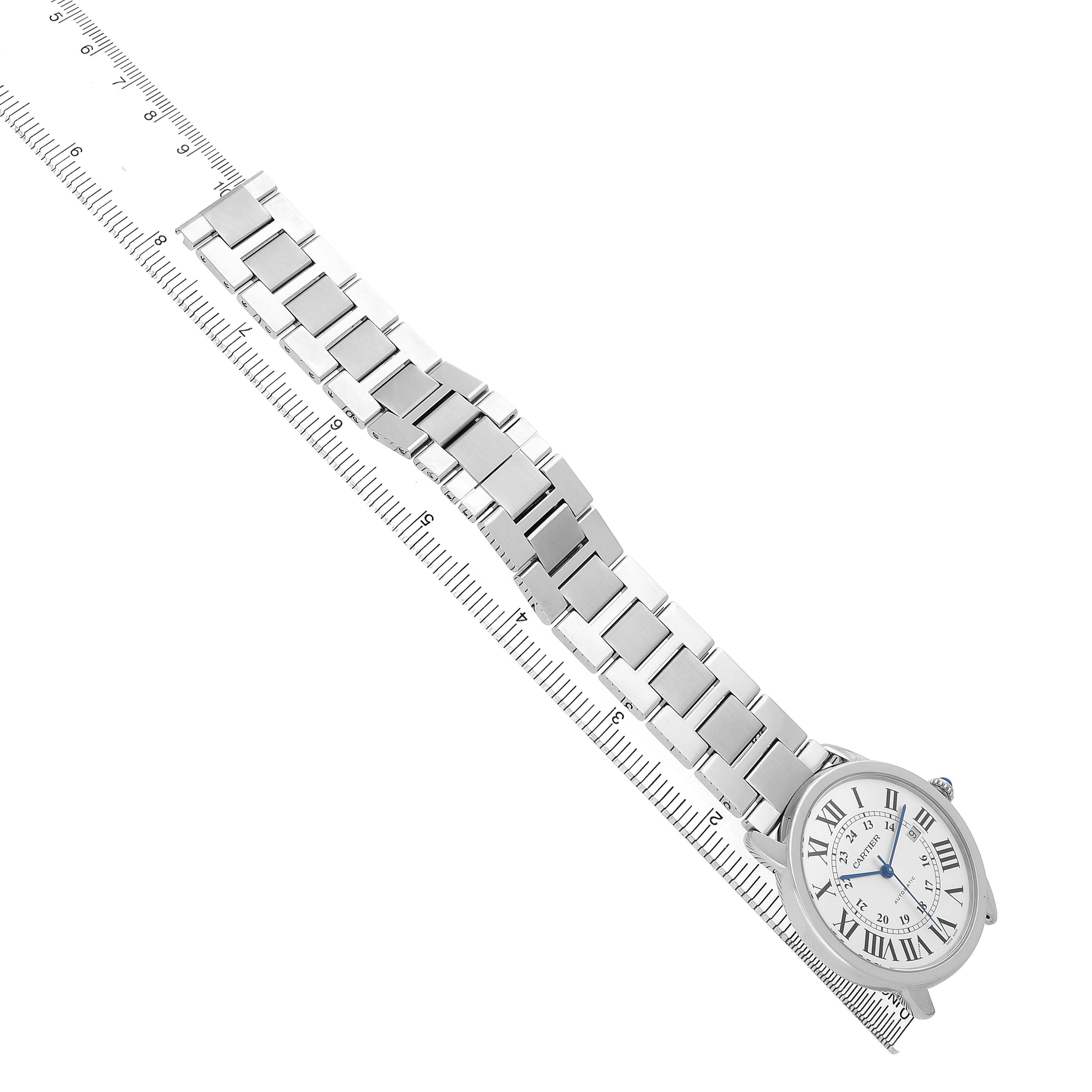 The Cartier Ronde W6701011 Men's Stainless Steel Silver Dial watch is shown from a top-down angle, displaying its face and metal bracelet laid alongside a ruler.