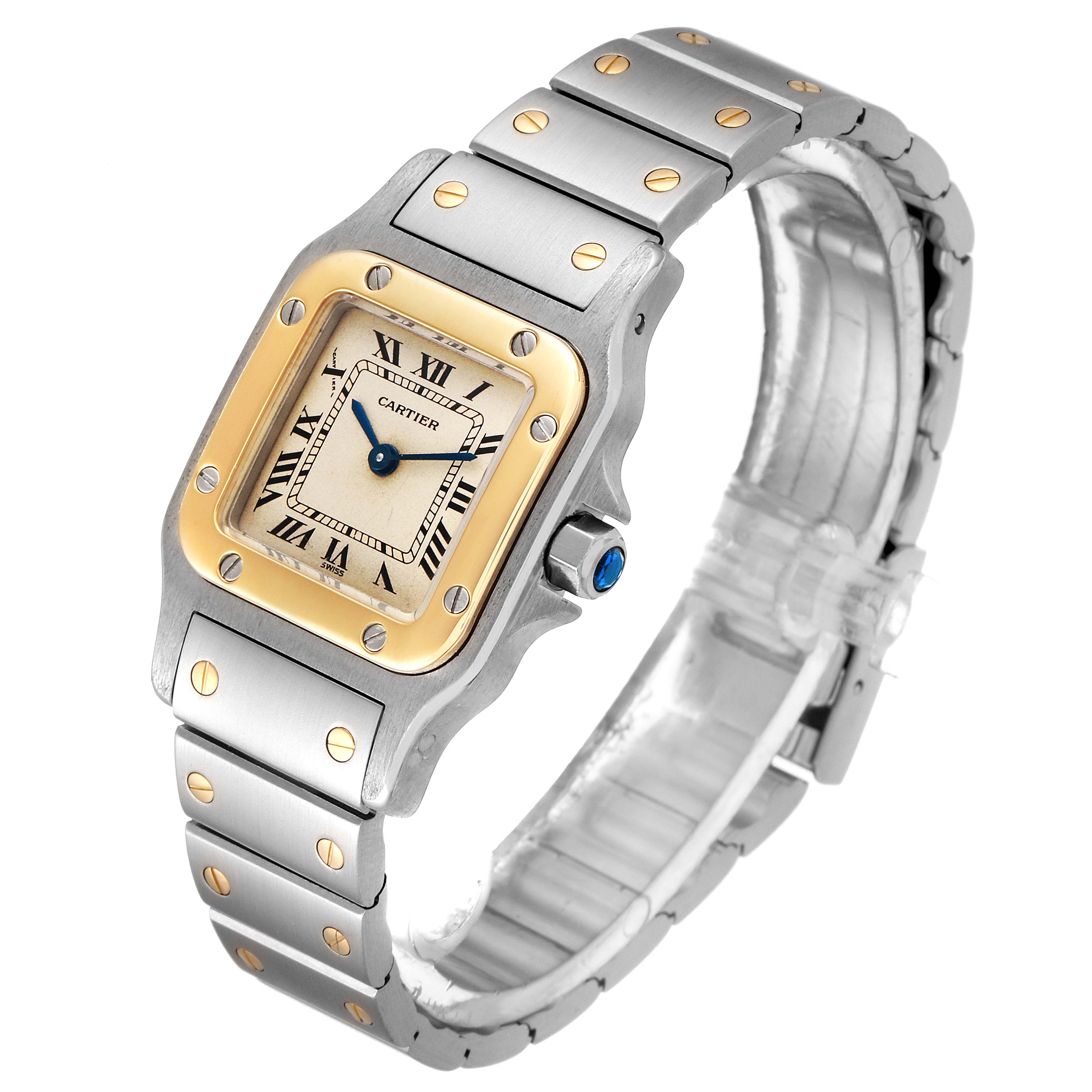 This Cartier Santos W20012C4 Women's Steel and Gold (two tone) Silver Dial W20012C4 Women's Steel and Gold (two tone) Silver Dial watch is shown at an angle displaying its square face, metal bracelet, and crown with blue detailing.