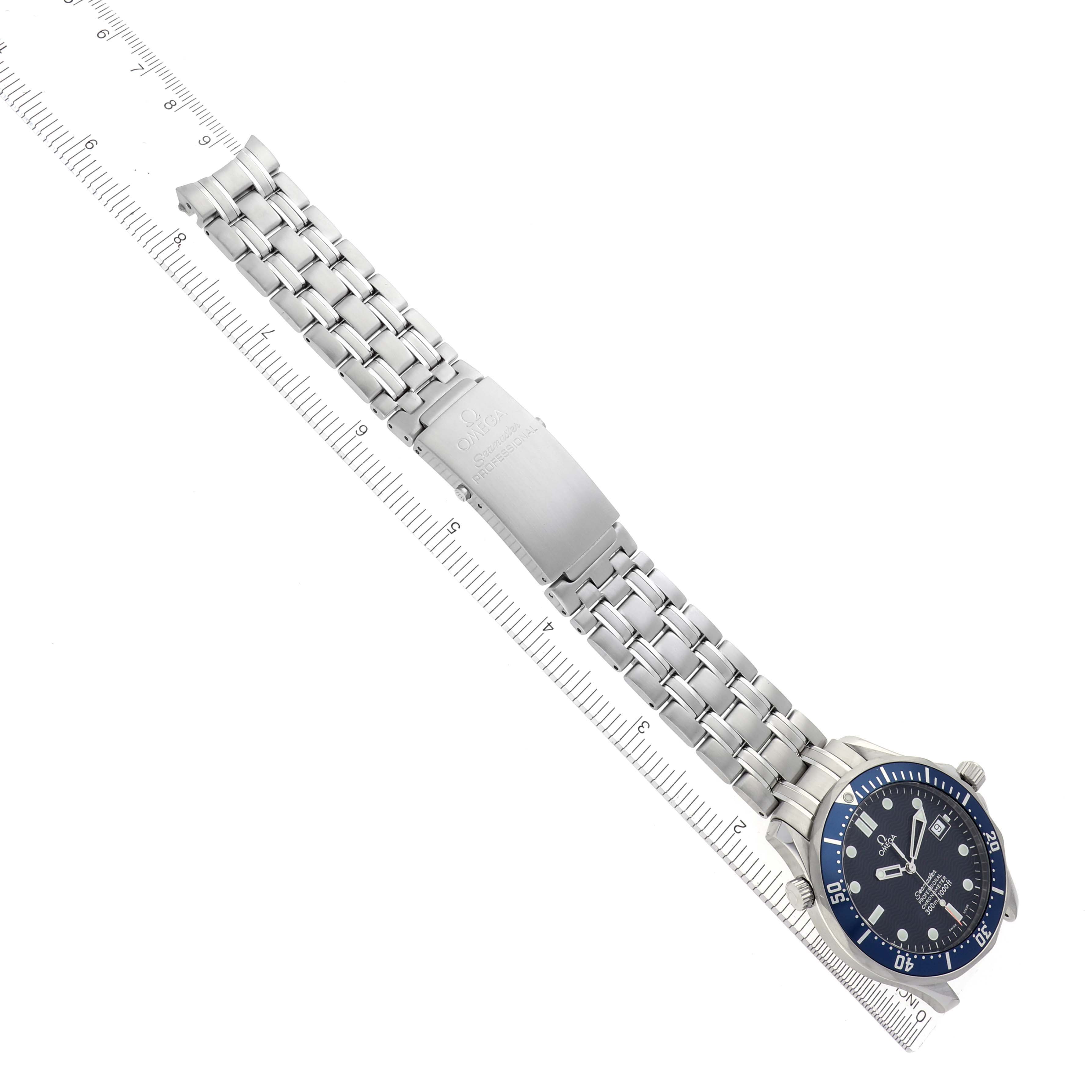 The Omega Seamaster 2531.80.00 Men's Stainless Steel Blue Dial 2531.80.00 Men's Stainless Steel Blue Dial watch is shown from a top view, displaying the face, full bracelet, and clasp next to a ruler.