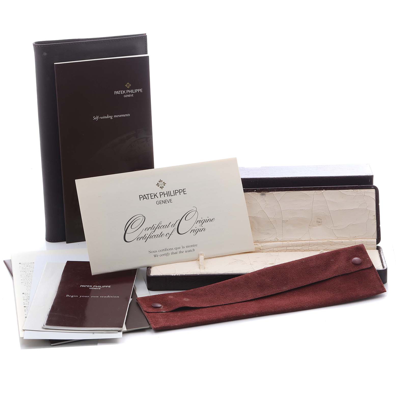 The image shows accessories for the Patek Philippe Calatrava 5107R Men's Rose Gold Silver Dial 5107R Men's Rose Gold Silver Dial, including manuals, a certificate, a case, and a pouch.