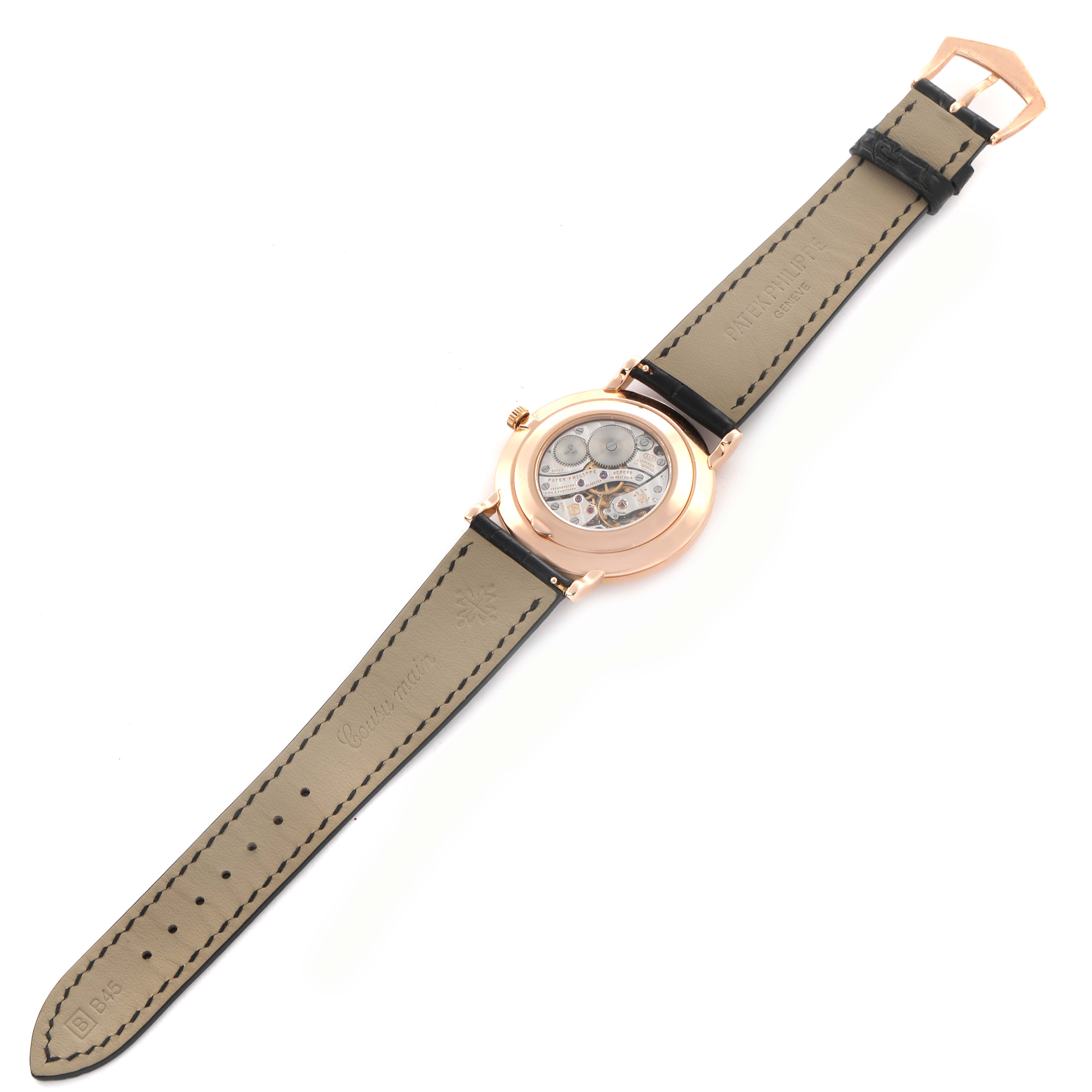 The image shows the back view of a Patek Philippe Calatrava 5119R-001 Men's Rose Gold White Dial 5119R-001 Men's Rose Gold White Dial watch, highlighting its mechanical movement and leather strap.