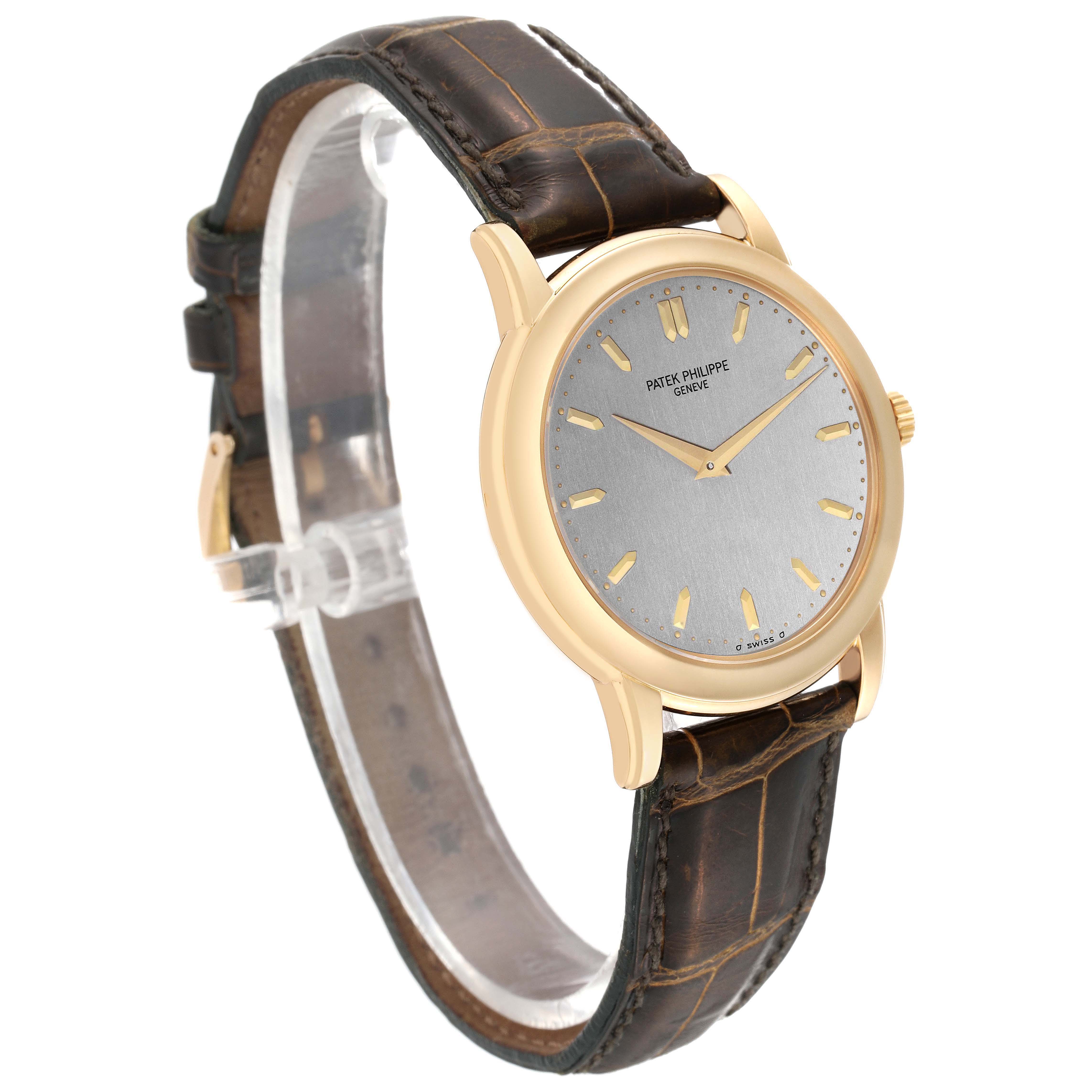 The Patek Philippe Calatrava 5032 Men's Yellow Gold Silver Dial 5032 Men's Yellow Gold Silver Dial watch is shown at an angled side view, highlighting its dial, case, and leather strap.