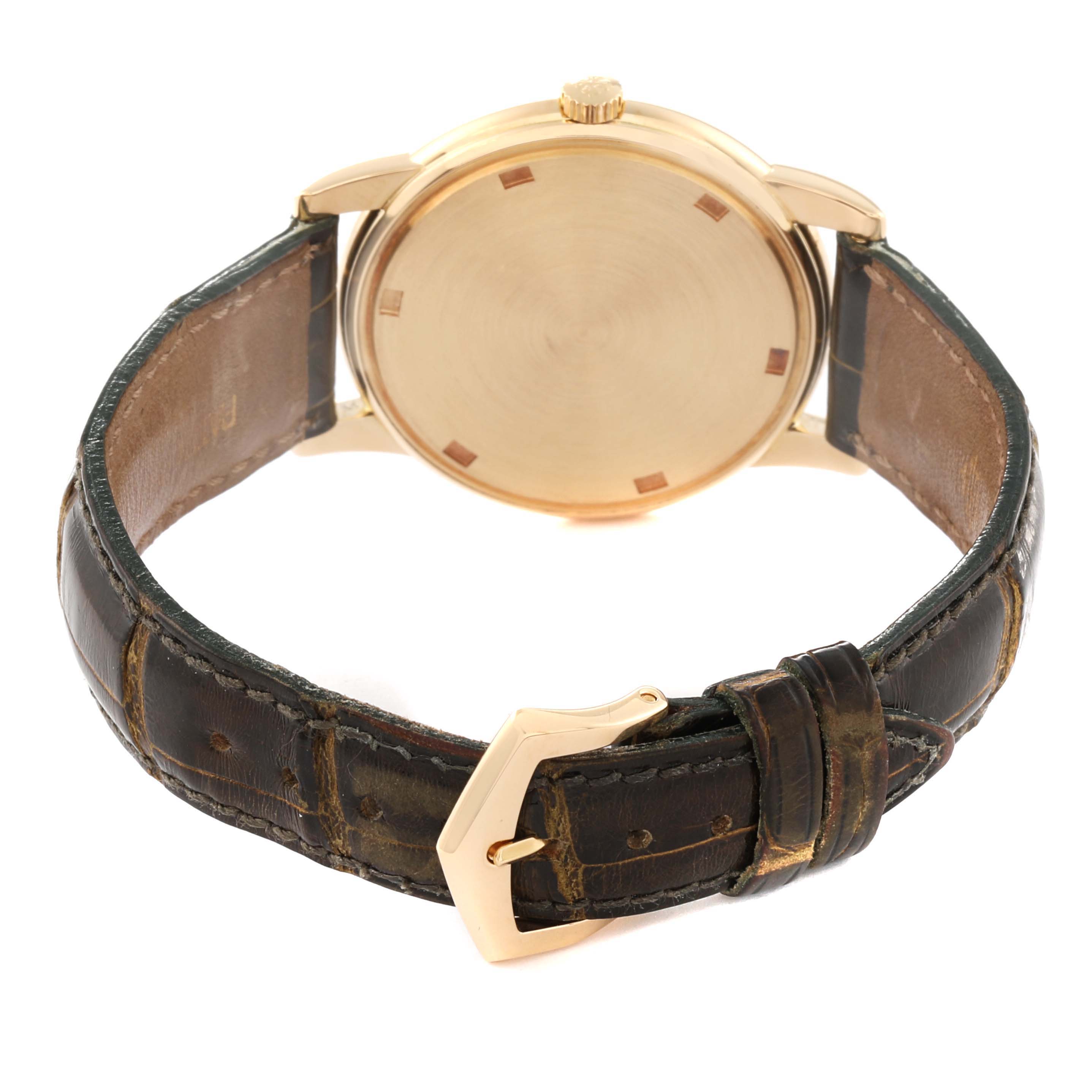 The image shows the back view of a Patek Philippe Calatrava 5032 Men's Yellow Gold Silver Dial 5032 Men's Yellow Gold Silver Dial watch with a leather strap and gold buckle.