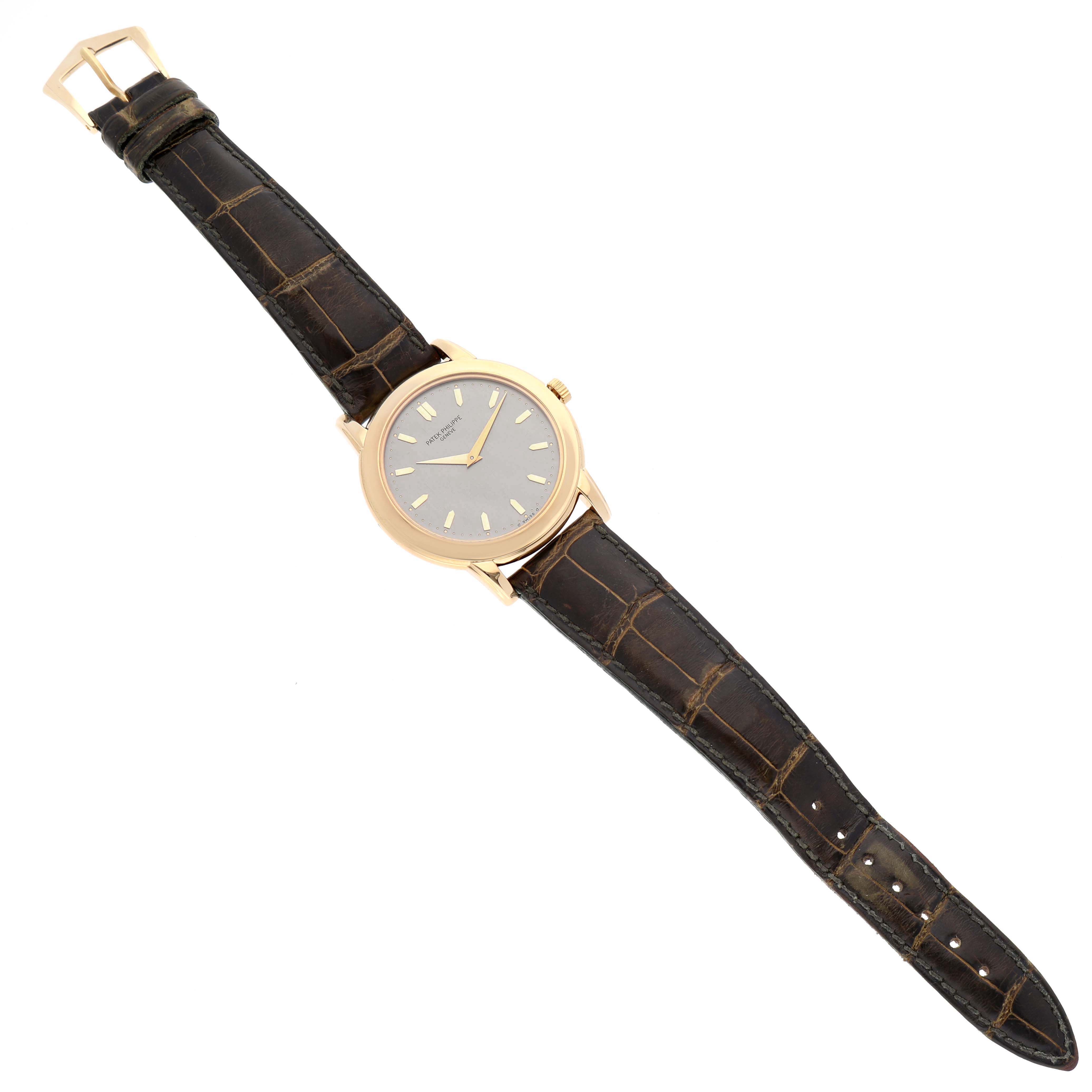 The image shows a top-down view of a Patek Philippe Calatrava 5032 Men's Yellow Gold Silver Dial 5032 Men's Yellow Gold Silver Dial watch, displaying the face, strap, and buckle.