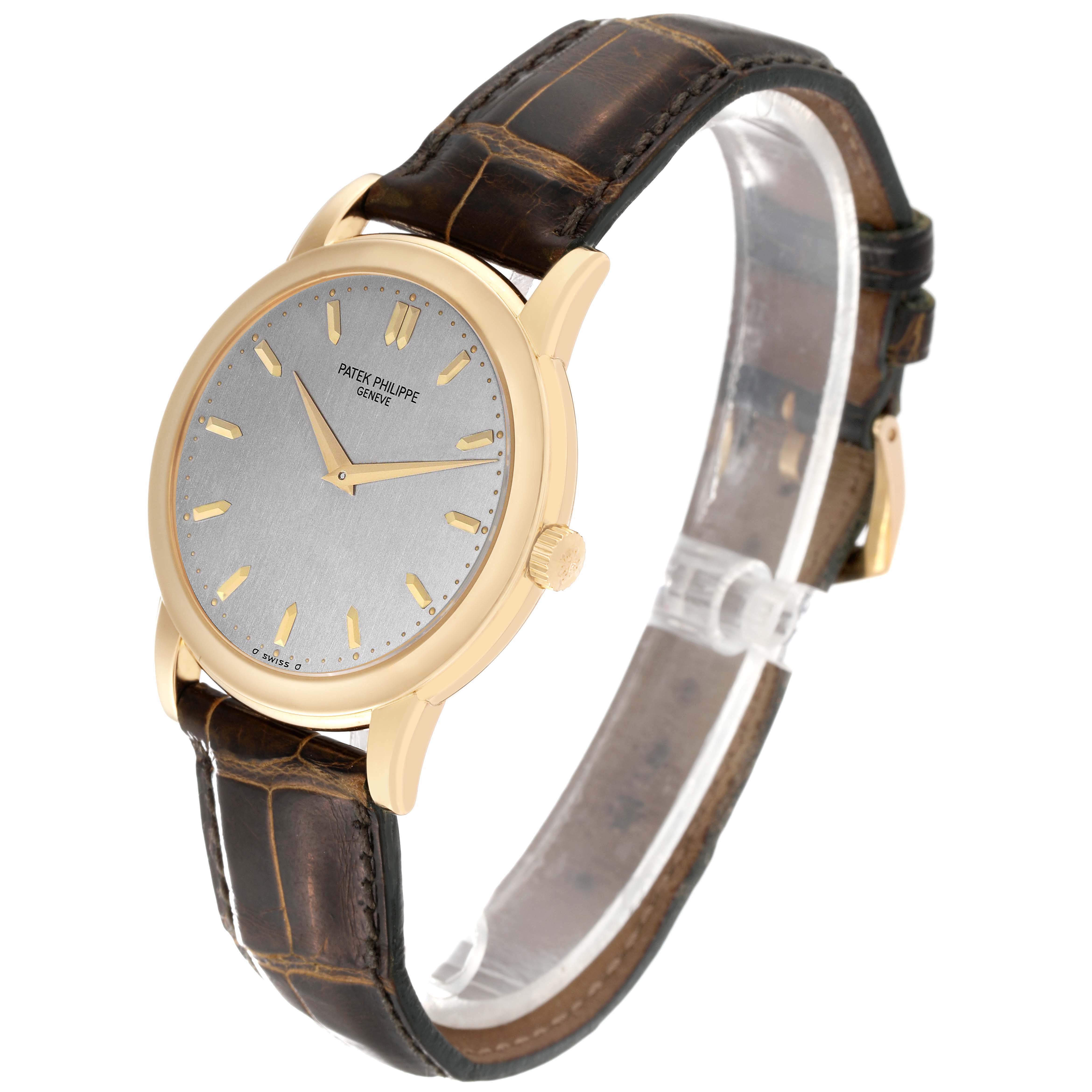 The Patek Philippe Calatrava 5032 Men's Yellow Gold Silver Dial 5032 Men's Yellow Gold Silver Dial watch is shown at a three-quarter angle, displaying the dial, case, crown, and leather strap.