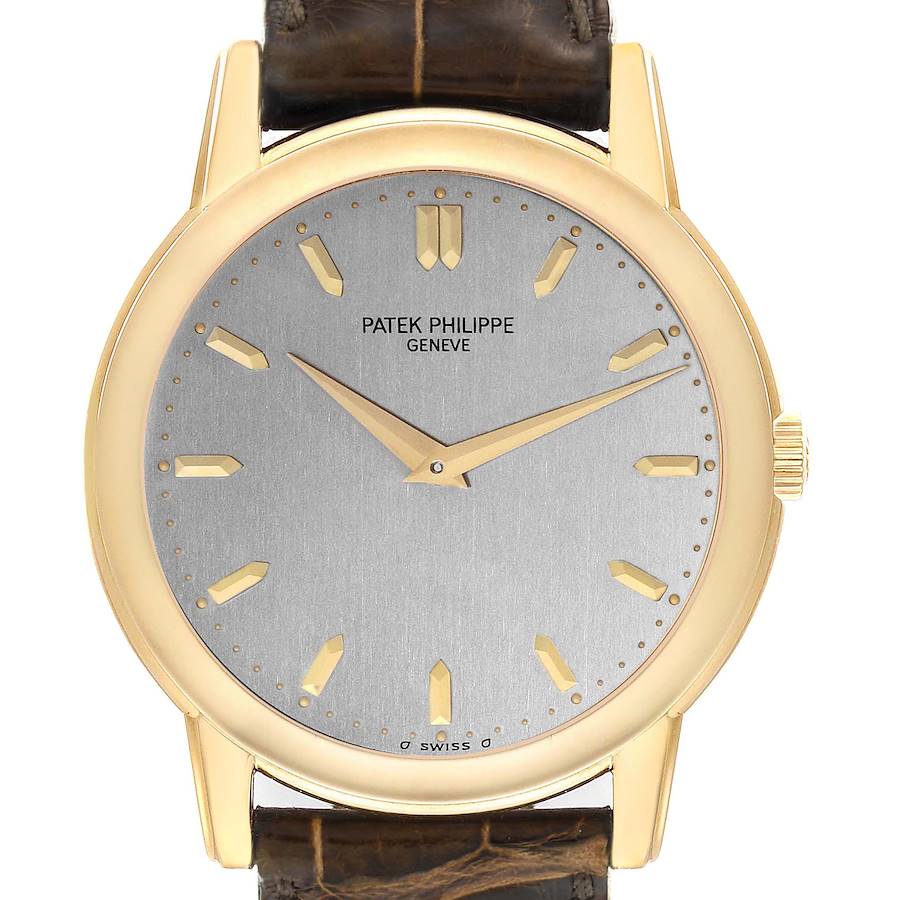 The Patek Philippe Calatrava watch is shown from the front, highlighting the dial, gold case, and leather strap.