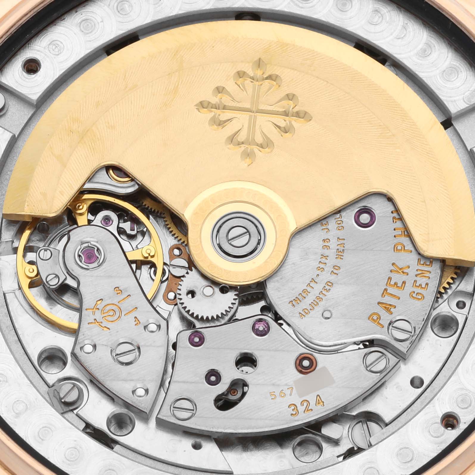 The image shows the Patek Philippe Complications 5146R Men's Rose Gold Beige Dial 5146R Men's Rose Gold Beige Dial watch movement from the back, highlighting gears and the engraved rotor.