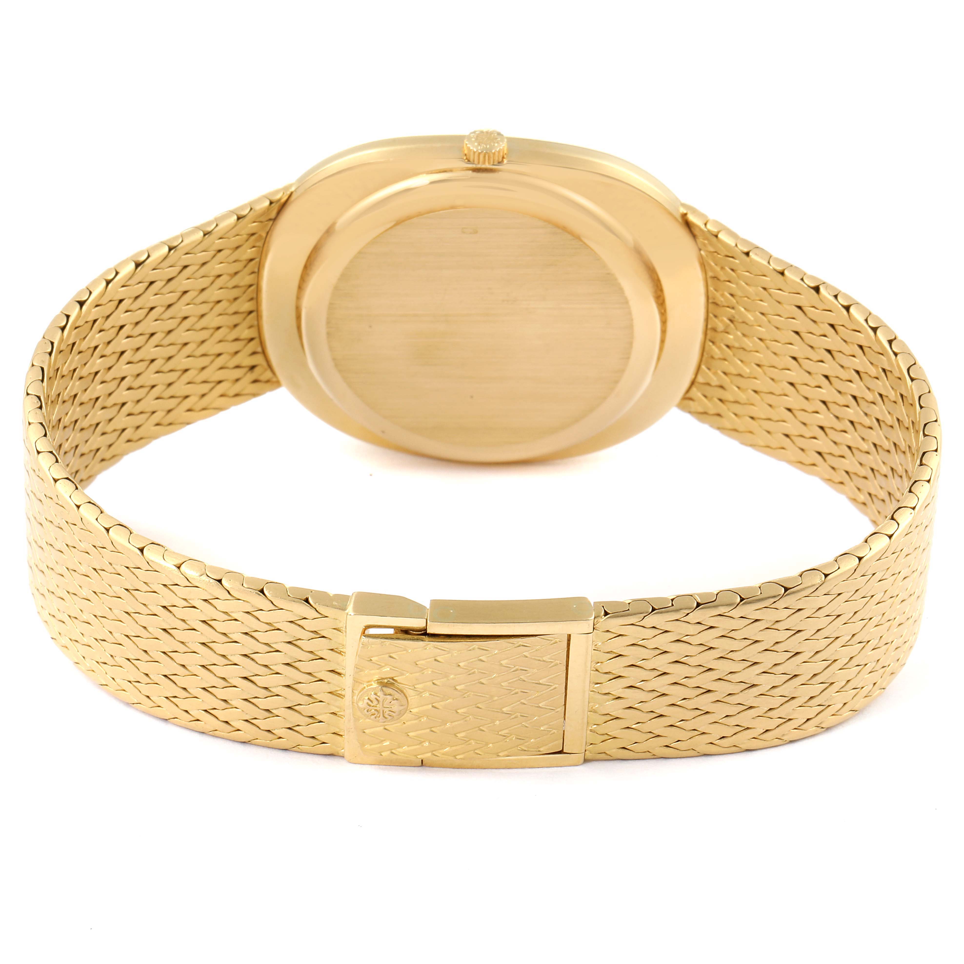 The image shows the rear view of a Patek Philippe Golden Ellipse 3605 Men
s Yellow Gold Champagne Dial 3605 Men
s Yellow Gold Champagne Dial watch, highlighting its gold case and woven bracelet.