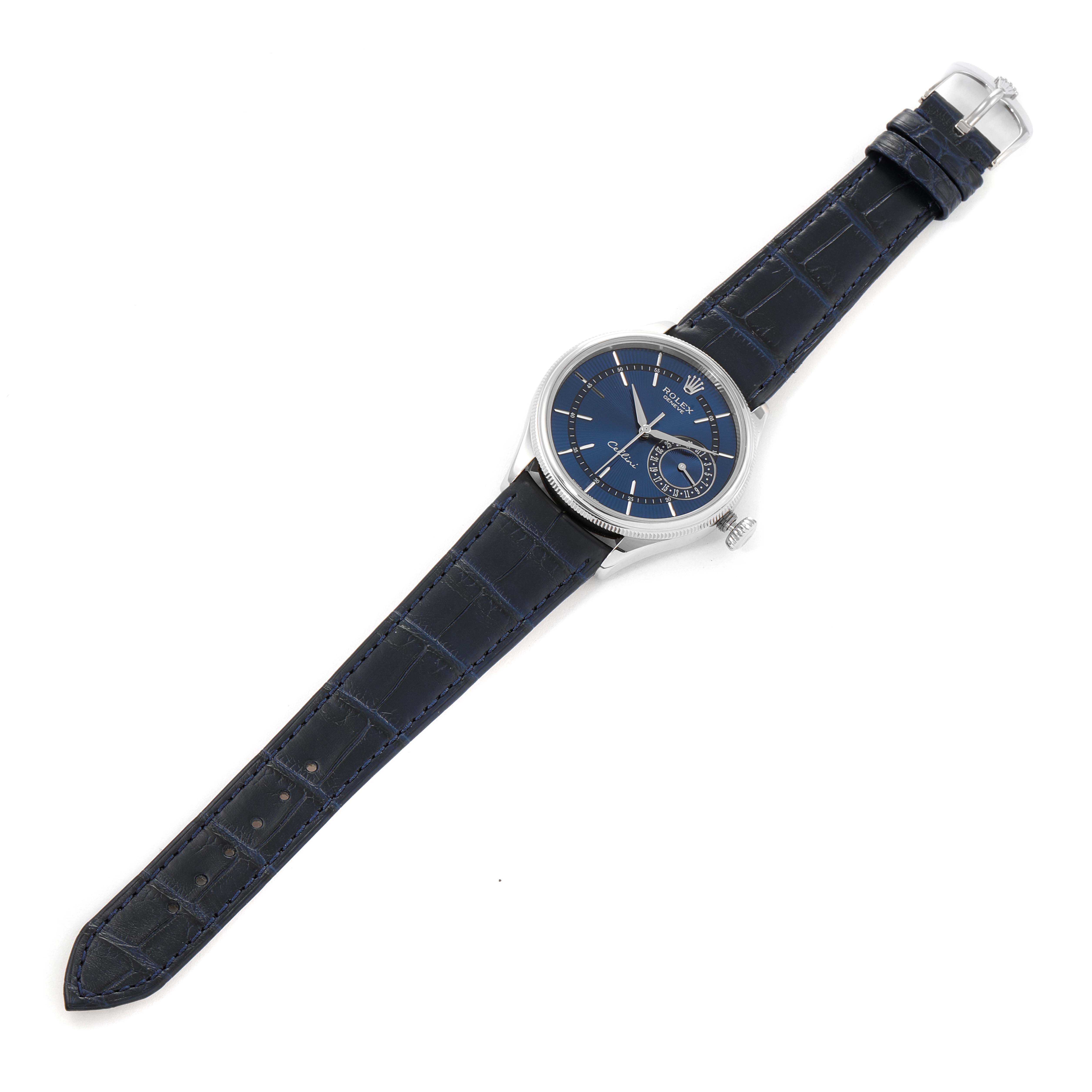 The Rolex Cellini 50519 Men
s White Gold Blue Dial 50519 Men
s White Gold Blue Dial watch is shown from a top-down angle, displaying its blue dial, silver casing, and blue leather strap.