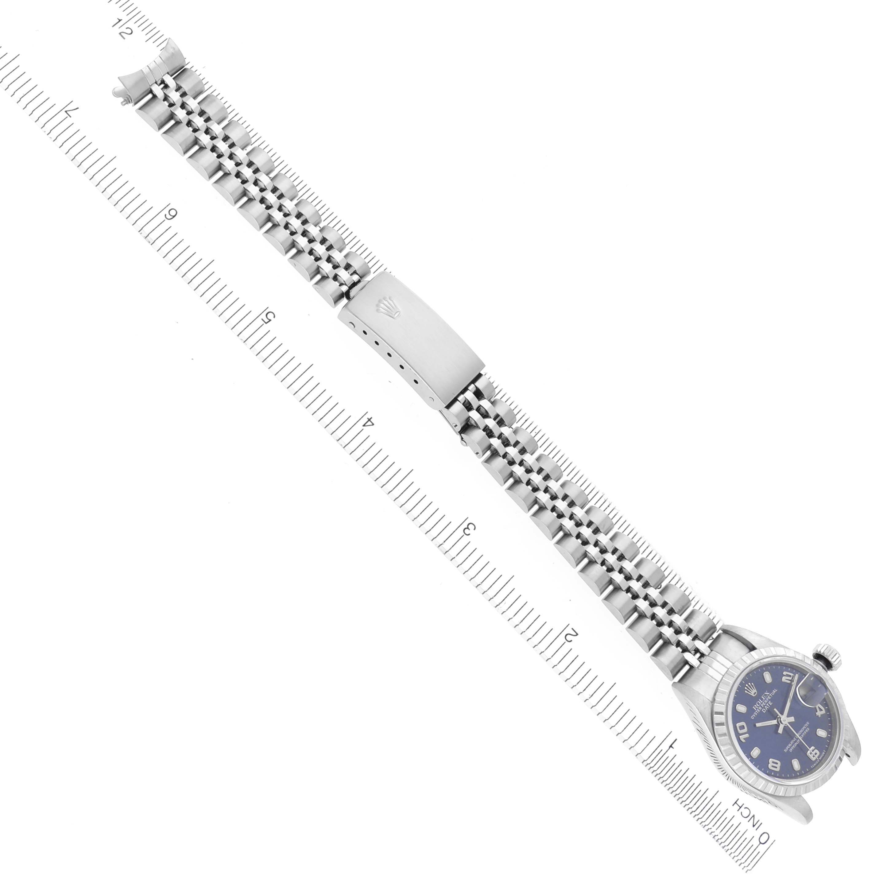 The Rolex Date 79240 Women's Stainless Steel Blue Dial 79240 Women's Stainless Steel Blue Dial watch is shown flat with a full view of the band and clasp, alongside a ruler for scale.