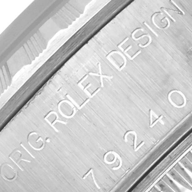 The image shows a close-up of the case engraving on a Rolex Date 79240 Women's Stainless Steel Blue Dial 79240 Women's Stainless Steel Blue Dial model, featuring the brand and model details.