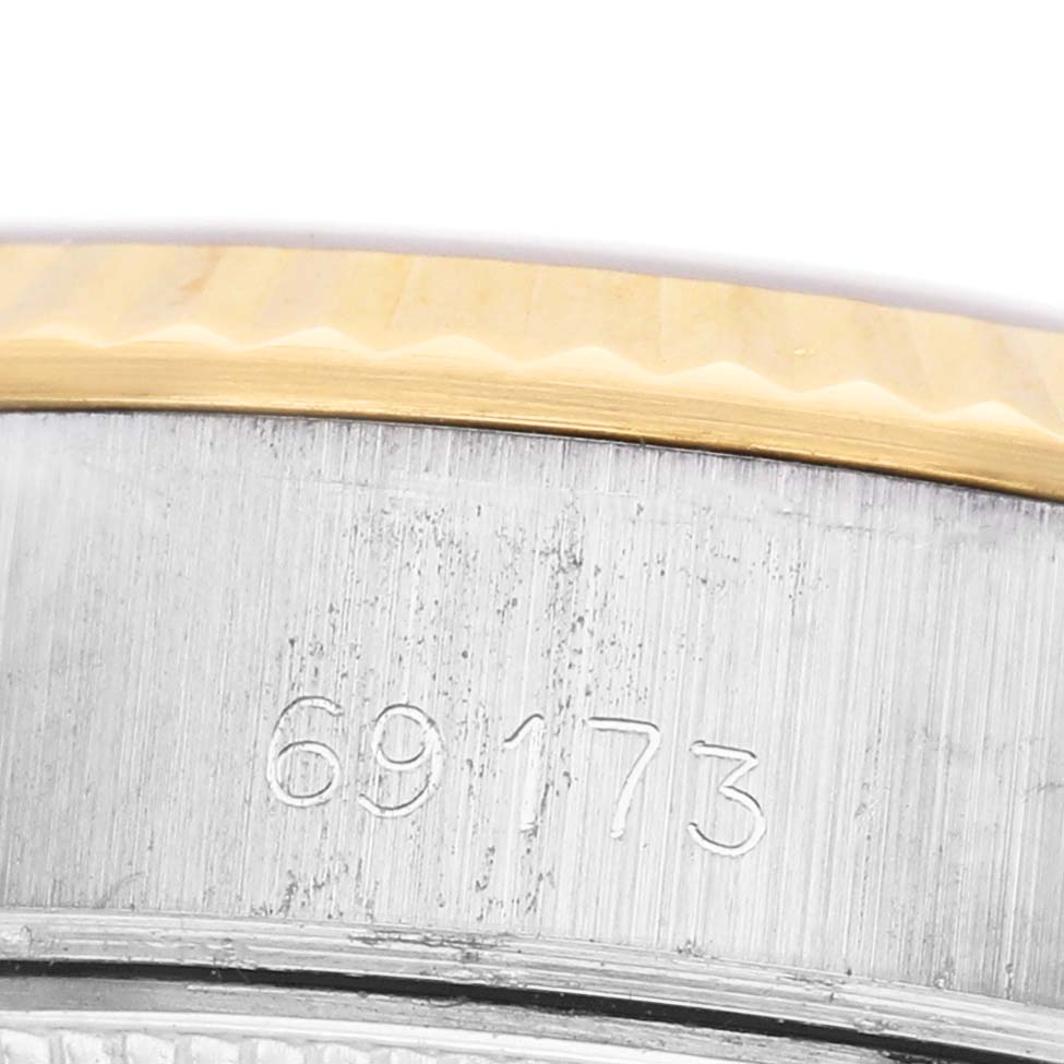 The image shows a close-up of a Rolex Datejust 69173 Women's Steel and Gold (two tone) Champagne Dial model's bezel and part of the case with engraved numbers.