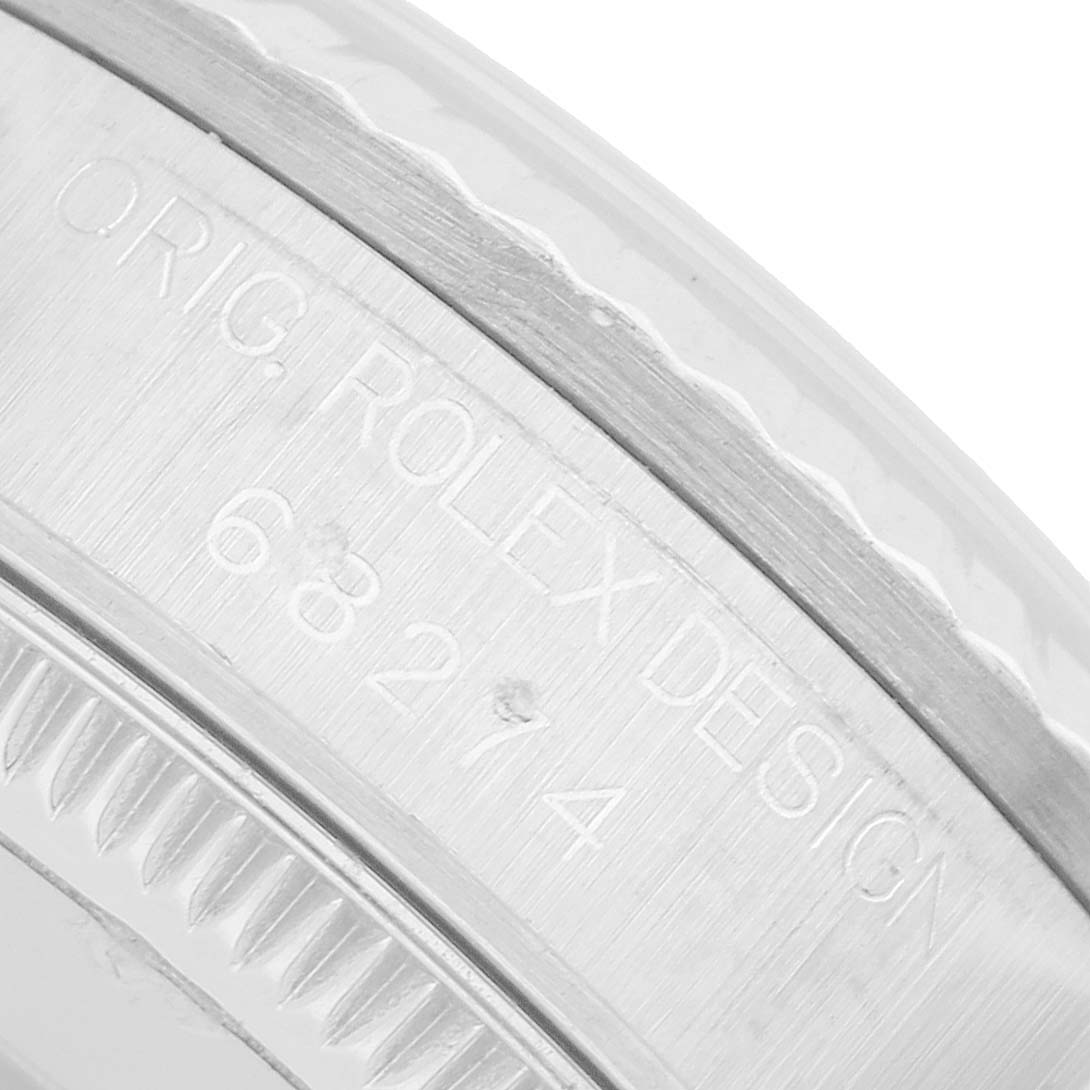 The image shows a close-up of the bezel and casing side of a Rolex Mid-Size 68274G Women's Steel and Gold (two tone) Silver Dial watch, highlighting the engraved design details.