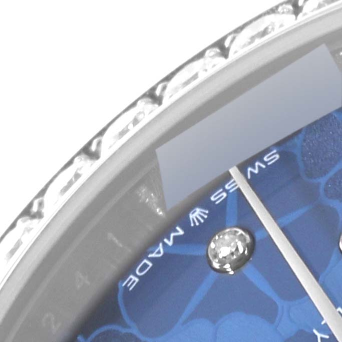 The image shows a close-up of the dial and bezel of a Rolex Mid-Size 278384 Women
s Stainless Steel Blue Dial 278384 Women
s Stainless Steel Blue Dial watch with a partially visible blue face and diamond markers.