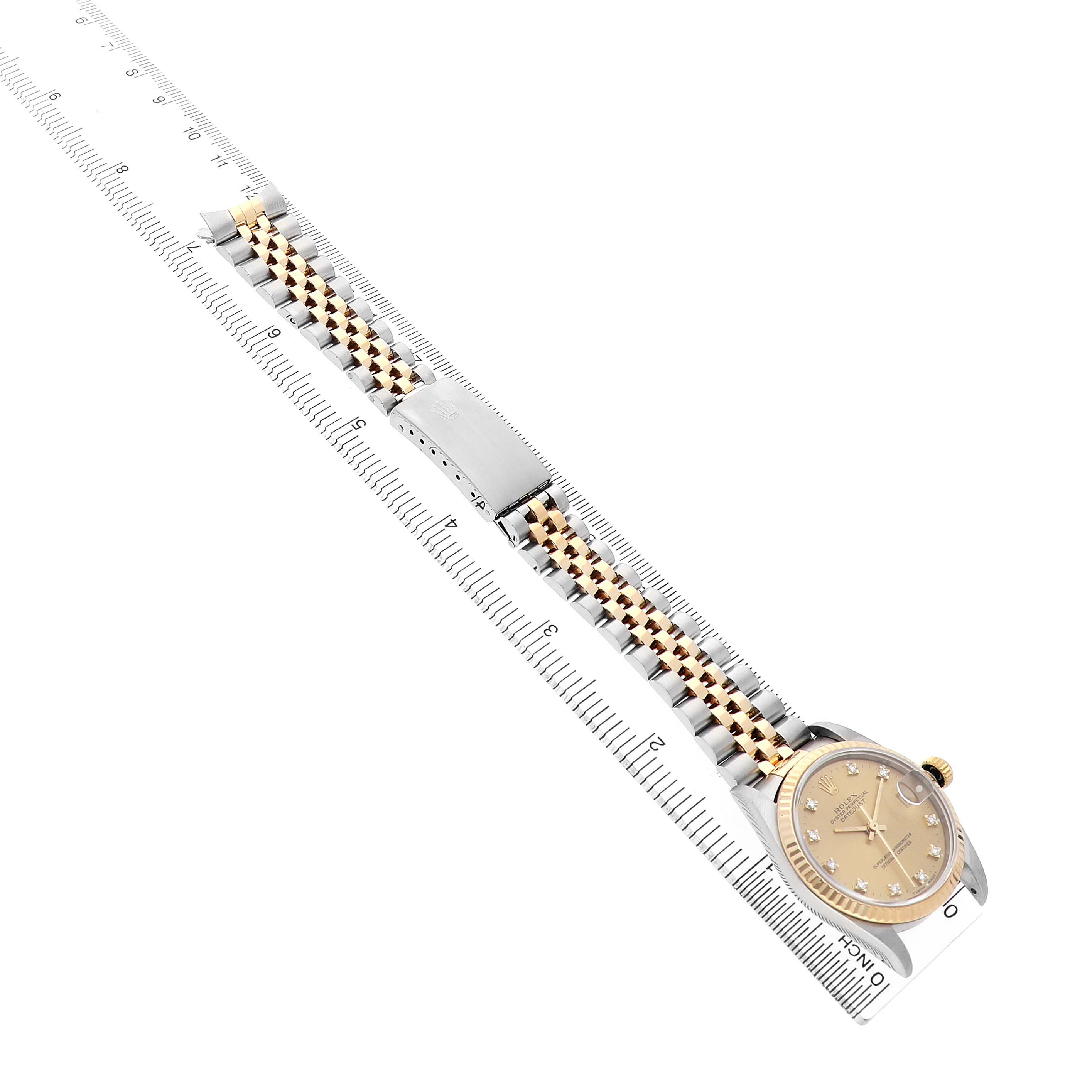 The Rolex Mid-Size 68273 Women's Steel and Gold (two tone) Champagne Dial watch is shown at an angled top view, displaying the face, bezel, bracelet, and clasp alongside a ruler.