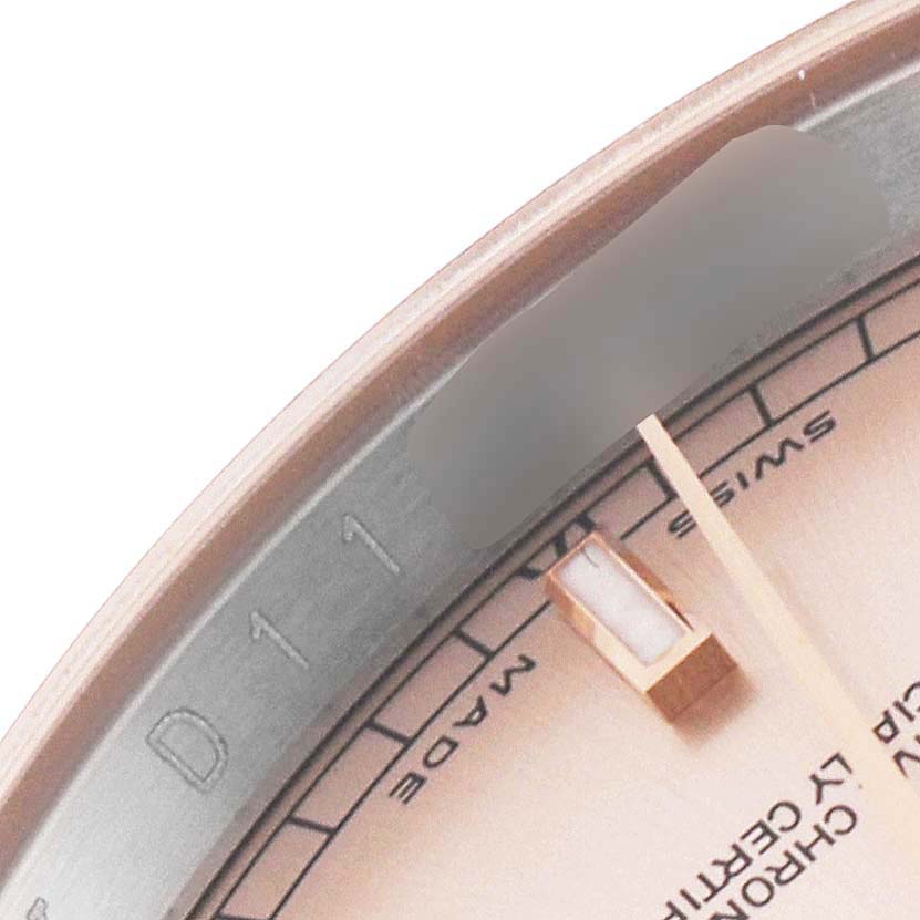 This close-up image of the Rolex Datejust 116231G Men's Steel and Gold (two tone) Pink Dial 116231G Men's Steel and Gold (two tone) Pink Dial shows its dial at an angle, along with part of its bezel and hour marker.