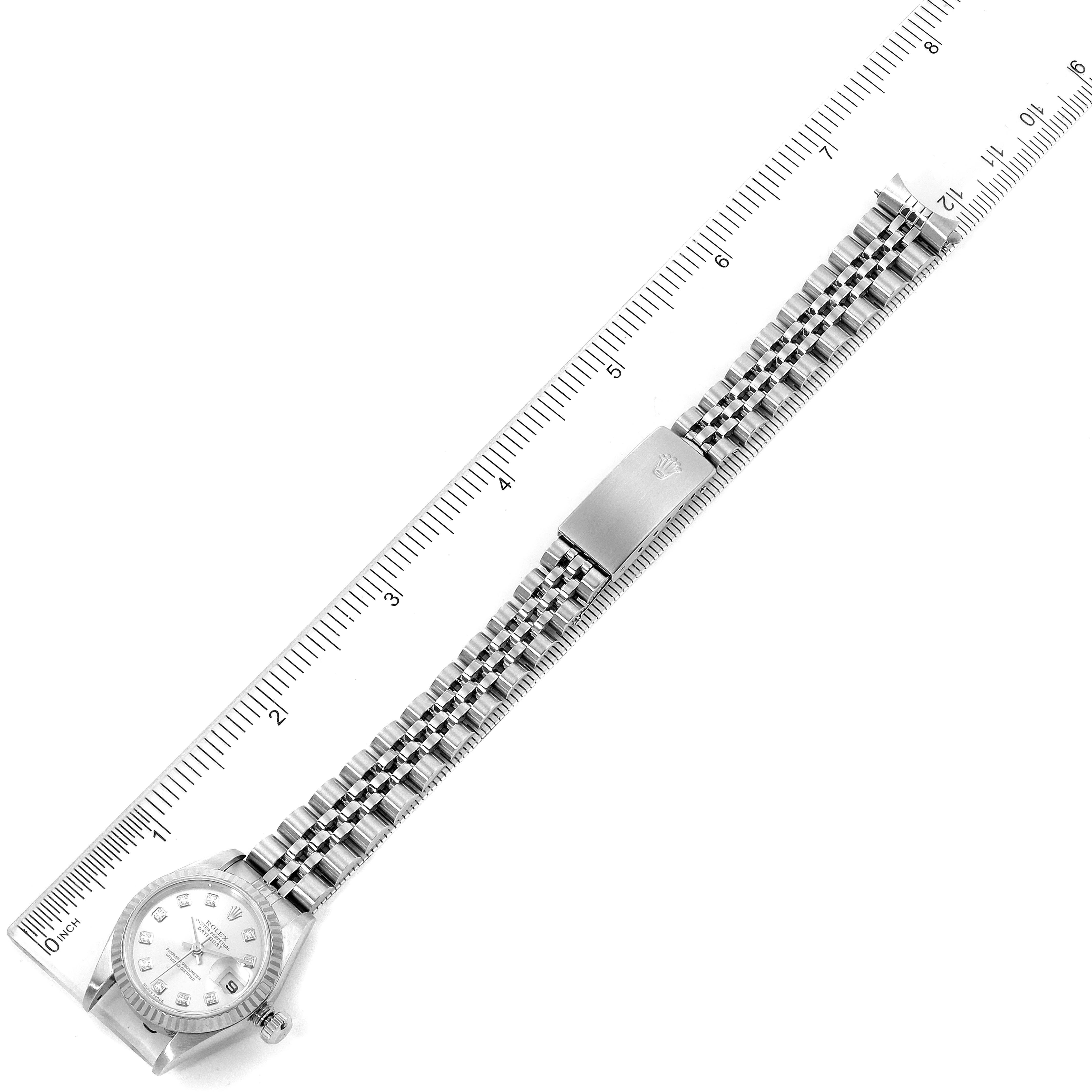 The image shows a top view of a Rolex Datejust 79174 Women's Stainless Steel Silver Dial 79174 Women's Stainless Steel Silver Dial watch, including the dial, bracelet, and clasp, with a ruler for scale.