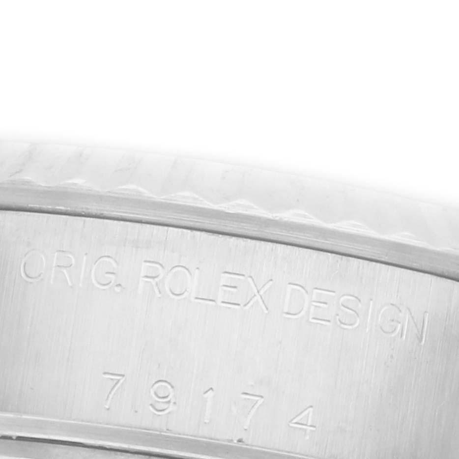 The image shows a close-up of the case side of a Rolex Datejust 79174 Women's Stainless Steel Pink Dial 79174 Women's Stainless Steel Pink Dial, featuring engraved design details.