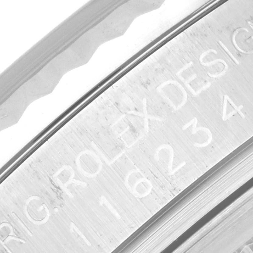 This close-up image shows the engraved "ROLEX DESIGN" and model number on the inner bezel of a Rolex Datejust 116234 Men's Stainless Steel Silver Dial 116234 Men's Stainless Steel Silver Dial watch.