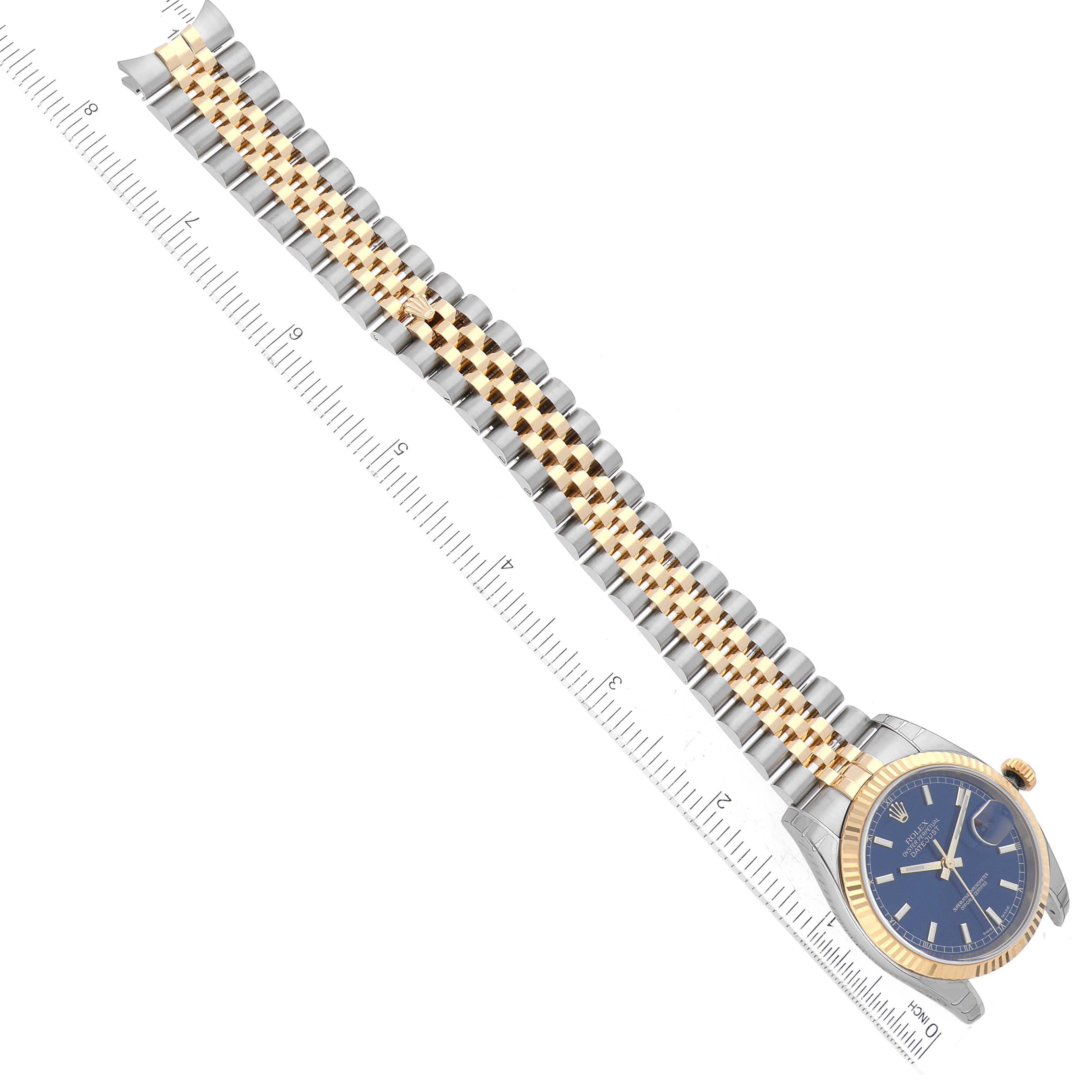 The image shows a top-down view of a Rolex Datejust 116233 Men's Steel and Gold (two tone) Blue Dial 116233 Men's Steel and Gold (two tone) Blue Dial watch, highlighting the face and full length of the bracelet next to a ruler.