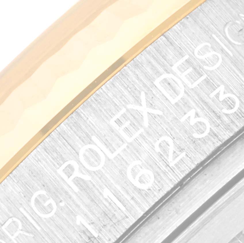 This close-up angle shows the side of a Rolex Datejust 116233 Men's Steel and Gold (two tone) Blue Dial 116233 Men's Steel and Gold (two tone) Blue Dial watch focusing on the engraved bezel details.