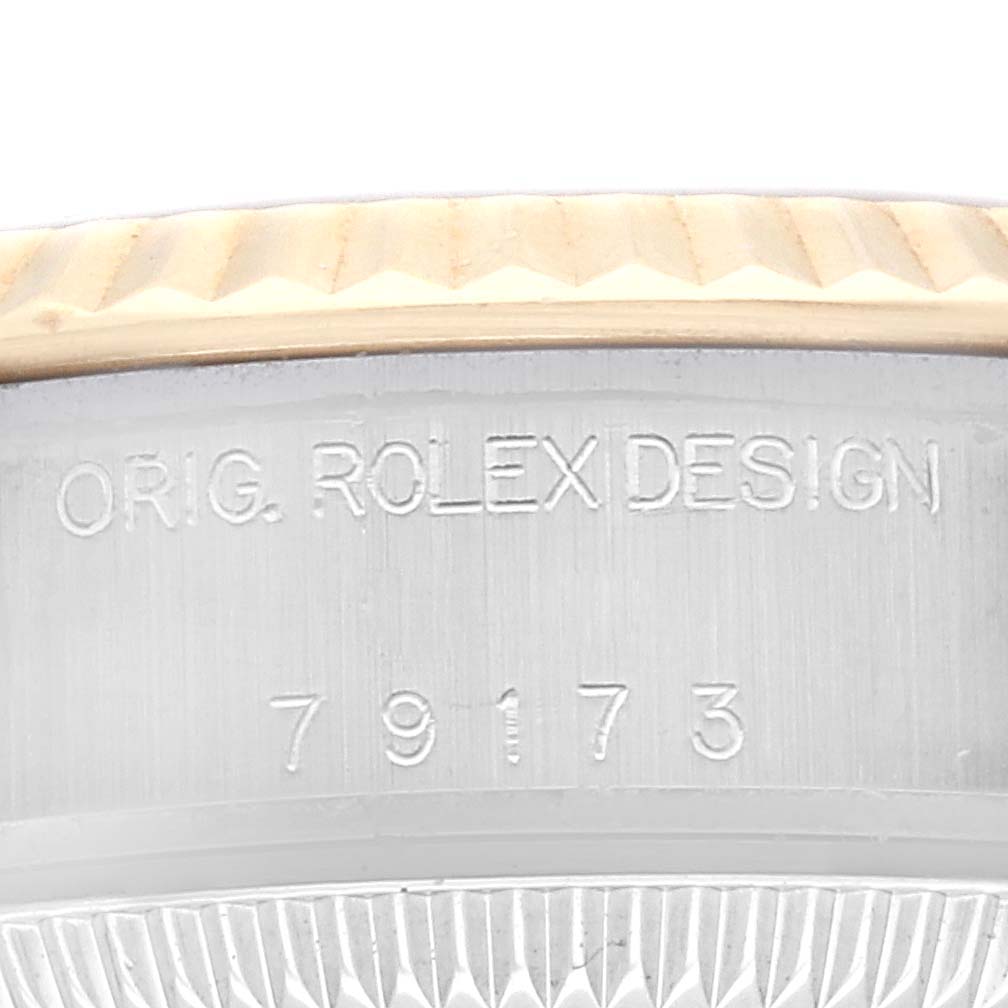This image shows an angled close-up of the case side inscriptions on a Rolex Datejust 79173G Women's Steel and Gold (two tone) Champagne Dial 79173G Women's Steel and Gold (two tone) Champagne Dial model, featuring the words "ORIG. ROLEX DESIGN" and the number "79173".