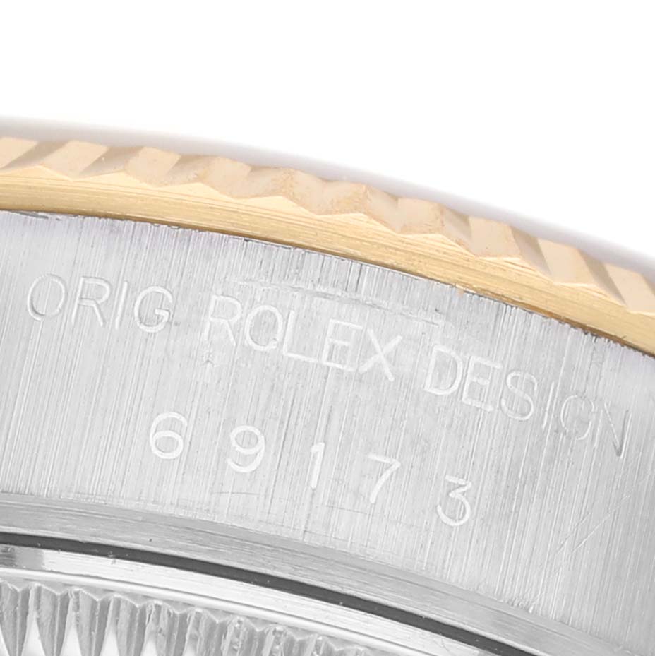 The image shows a close-up of the side of a Rolex Datejust 69173 Women's Steel and Gold (two tone) Champagne Dial, focusing on the model number and design engraving.